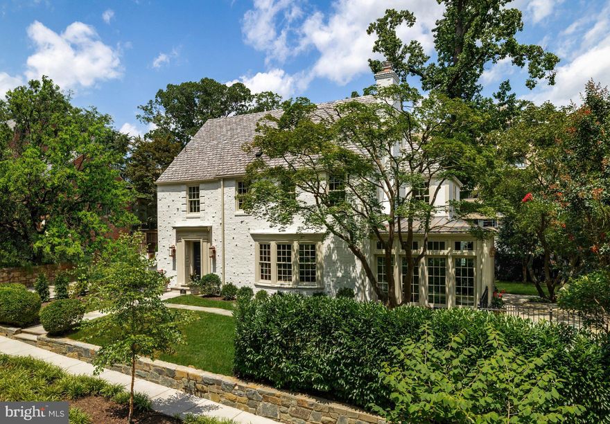 Gracefully set on a beautiful parcel in the heart of coveted Massachusetts Avenue Heights, 2825 McGill Terrace NW is a classic 1929 home reimagined with sumptuous contemporary elegance, all while honoring its timeless ethos. A visionary masterpiece by Kent Construction & Development, this residence is the result of a meticulous collaboration with acclaimed interior designer Zoe Feldman and renowned landscape architect Joseph Richardson. Together, they have left no detail untouched in crafting one of Washington’s most distinguished luxury homes.
 
A thoughtfully designed entry reveals the rejuvenated historic brick façade, now finished in a light, refined hue and accented by new Andersen windows. A slate and copper roof adds stately contrast, while an attached two-car garage is discreetly tucked away. A flagstone walkway offers a suitably regal welcome to the foyer. Inside, original parquet floors and a formal powder room with a freestanding Italian marble vanity introduce the floor plan, which spans over 5,000 square feet across four levels of refined living. Finishes from Baldwin, Restoration Hardware, Forbes & Lomax, Waterworks, and Rejuvenation speak to the no-expenses-spared approach throughout.
 
Step down into the formal living room, a nearly 26-foot-long, embassy-sized space featuring dark walnut-stained oak floors, a custom Italian marble fireplace, and elaborate crown molding. A Sonos sound system envelops the main level, perfect for entertaining. The adjacent dining room is bathed in natural light from two walls of glass and connects seamlessly to the kitchen via a serene breakfast room.
 
At the heart of the informal spaces lies the chef’s kitchen, an architectural statement anchored by a custom arched hood lined with imported Australian clay tiles. Custom inset cabinetry, unlacquered brass hardware, unbroken slabs of Taj Mahal quartzite, a walnut island topped in black soapstone, and top-tier appliances from Sub-Zero, Wolf, and Miele define the space’s exquisite functionality. The adjoining family room features custom built-ins and an L-shaped bar with Brazilian quartzite countertops, perfect for relaxed gatherings.
 
The main staircase leads to a central upper-level vestibule. The primary suite occupies its own wing, with a private IPE balcony and two custom walk-in closets. Outfitted with a dedicated Sonos zone, the suite offers a serene, fully integrated retreat. Inspired by the world’s finest spas, the bath showcases bold Moroccan hand-made Zellige tile, Waterworks fixtures, a floating tub, dual vanities, and a walk-in glass shower with two large rain shower heads and body spray. Two additional ensuite bedrooms and a laundry room complete this level. The expansive top floor offers a full bath, a cedar closet, and two additional bedrooms – ideal for guest space, an office, or a yoga studio.
 
Downstairs, the nearly 48-foot-long recreation room creates a generous space for entertaining or lounging. A powder room, second laundry, and gym occupy one end, while a soapstone bar and glass-enclosed wine room with adjacent open wine lounge elevate the opposite side. Behind the scenes, smart systems include Nest thermostats for three new efficient, gas-fired Carrier HVAC systems, a new 80-gallon electric water heater, and a comprehensive ADT security system with security cameras throughout. Fenced and shaded by a lush canopy, the private grounds complete this extraordinary offering.
 
Rich in history, reimagined with precision, and elevated to modern luxury’s highest standard, 2825 McGill Terrace NW stands peerless among Washington’s most exceptional homes.