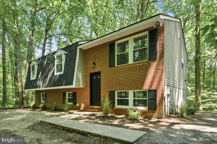 Beautifully updated modern split foyer home on private, wooded lot. Open floor plan boasts bright, light filled kitchen with white, soft close cabinets, quartz countertops, spacious island, stainless steel appliances and dining area.  The kitchen opens up to a large, brand new deck that boasts a magnificent forested view.  The main level includes three bedrooms and two full bathrooms, highlighted by an owner's suite with an en suite bathroom.  The spacious lower level walks directly into the backyard which allows tons of natural light.  Also included in the lower level are an oversized rec room with a wood burning fireplace and two private rooms which could be used as offices, dens or walk out spaces.  Brand new roof, HVAC, water heater, windows, electrical and plumbing.  This one is move-in ready!