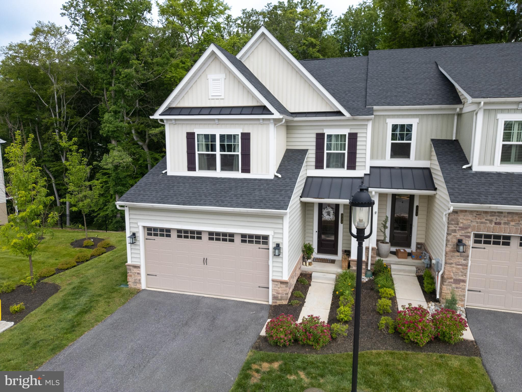 Discover an unparalleled lifestyle in this meticulously maintained and generously appointed end-of-row true 4 Bedroom, 3.5 bath townhouse nestled in the prestigious Ponds Edge Community in Media Boro. Built in 2022, this residence seamlessly blends transitional, colonial, and contemporary architectural styles, offering a sophisticated yet inviting atmosphere. This home sits on a lot that is part of the premium lot package originally reserved for builder's model homes. Step inside to experience the grandeur of an open floor plan, where luxury vinyl plank flooring and elegant quartz finishes create a harmonious flow throughout the entire residence. The heart of the home is the gourmet kitchen, featuring upgraded countertops, stainless steel appliances, and a five-burner stove, perfect for culinary enthusiasts. The kitchen's island and breakfast area invite casual gatherings, while the formal dining room sets the stage for more intimate dinners. The spacious family room, adorned with a stunning gas fireplace framed by marble surround, is an ideal retreat for relaxation or entertaining. Natural light floods the space through double-pane windows, enhancing the home's warmth and charm. The main level also boasts a convenient half bath and walk out deck to a "True Wooded Backdrop". Retreat to the luxurious primary suite, complete with a large walk-in closet, tray ceilings and a spa-like bathroom featuring a floor to ceiling designer tile walk-in shower and an oversized 2-sink vanity with beautiful quartz counter tops that's paired beautifully with designer fixtures and lighting. The 2nd floor also hosts 3 additional bedrooms, all generously sized and features walk in closets custom window treatments. Rounding out a long list of features on the upper level is the ultra-convenience of a full laundry room with a High Efficiency washer & dryer included. The fully finished basement offers versatility, whether as a media room, gym, or play area, with an owner added bar that brings a flex space for all types of events and gatherings. The basement also includes a full bath and walkout access to the beautifully landscaped rear yard. Outside, the corner lot provides a premium setting, backing to serene trees that offer privacy and tranquility - a "True Wooded View". Enjoy the outdoors on your expansive deck, perfect for morning coffee or evening gatherings. The meticulously maintained grounds are complemented by community amenities, including a clubhouse, fitness center, and common areas, all covered by the association fee for your convenience. With an attached oversized garage and additional driveway parking, your vehicles are well accommodated. Security features, including exterior cameras and a monitored system, provide peace of mind. Located less than a mile from the Wawa Station on Septa's Regional Rail for direct access into Philadelphia, and just a short drive to the airport, this home offers both convenience and luxury. Experience panoramic views of the surrounding woods and streets, making this property not just a home, but a lifestyle. Just minutes from the downtown restaurant scene and minutes to many shopping options and the always popular commuter rail line. Rose Tree Media School district continues to rank among the nation's best! Embrace the elegance, comfort and convenience that awaits you in this exceptional residence at Ponds Edge.