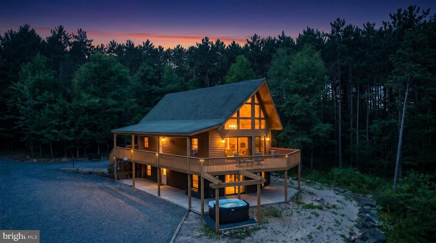 Log Style Home near Deep Creek Lake! Situated on 1.5 private wooded acres, this 3-bedroom Chalet delivers the perfect blend of mountain charm and functional living. The warm wood interior, soaring ceilings, and exposed beams create an inviting great room centered around a stunning stone fireplace. An open-concept layout connects the living, dining, and kitchen areas, offering an ideal space for gathering and entertaining.
Multiple sleeping areas, including a spacious loft, provide flexibility for guests, while the finished lower level adds additional living space complete with rec space for year-round enjoyment. Step outside to expansive wraparound decking and covered outdoor spaces designed for relaxing or hosting, along with a hot tub and fire pit area that embrace the natural setting.
Very private with a generous yard and ample parking, this home offers both seclusion and convenience—just minutes to Deep Creek Lake, Wisp Resort, state parks, and local establishments. Whether you're seeking a full-time residence, second home, or investment opportunity, this property captures the essence of mountain living.