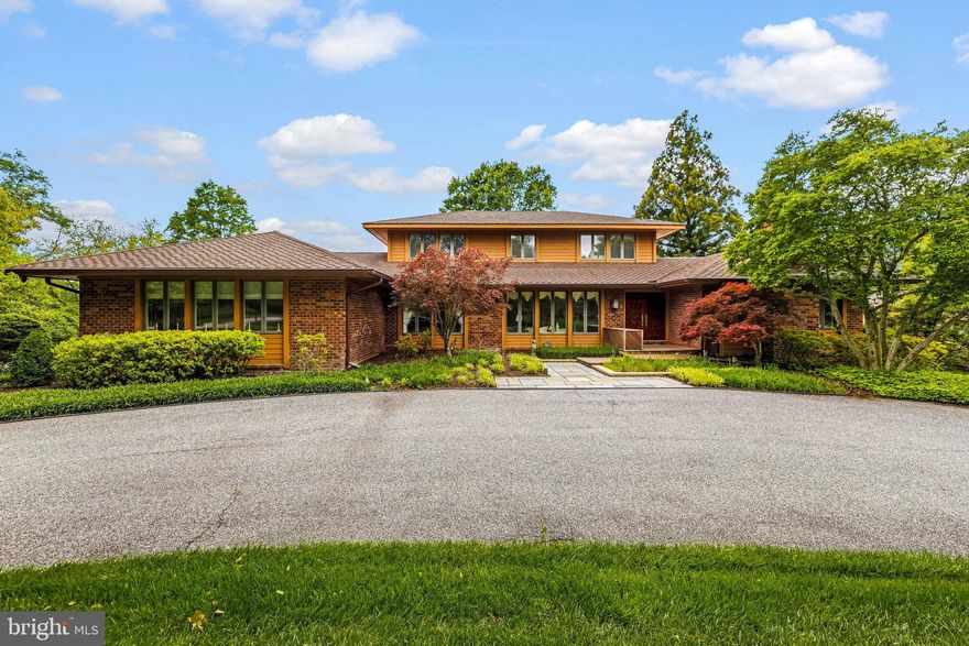 Designed by Donald Ratcliffe in the fashion of Frank Lloyd Wright! Expansive main level, paneled double doors welcome visitors to Foyer, spacious formal Living Room and Dining Room. Large Family Room with stone fireplace opening to 2-level Deck. Eat in Kitchen granite counters, island and double wall oven. Office with 3 walls of window, wet bar and sliding doors to Deck. Primary suite with fireplace, custom walk-in closet and large Bath. Additional Main Level Bedroom/Den with fireplace and private Bath. Laundry Room, Mudroom, 2 Powder Rooms and oversize 3-car Garage complete the main level. Two bright and sunny large Bedrooms and Hall Bath are found on the Upper Level. Full, partially finished Lower Level includes a Powder Room. Accessed from the Family Room, Kitchen, Office and Primary Bedroom is the 2-level engineered wood deck with steps to the flat back yard. Professionally landscaped and maintained .6 acre lot in The Meadows of Greenspring.