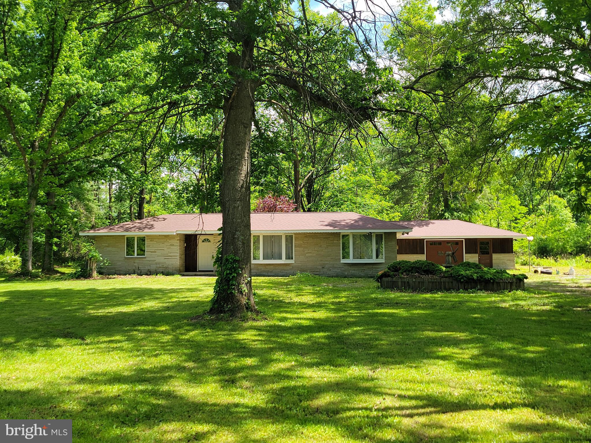 Contemporary Rancher on 7 Acres With Stream – Unique Design, Natural Setting - Discover this one-of-a-kind contemporary ranch-style home nestled on 7 serene acres, bordering trout-stream (Little Antietam Creek) and abundant open space—perfect for those seeking tranquility and room to roam. This distinctive property features a private central courtyard that brings natural light into the heart of the home. Inside, you’ll find an open floor plan with combined living room/dining room, large eat-in kitchen, 3 spacious bedrooms and 1.5 bathrooms, optional 4th bedroom/study, and a welcoming family room with a cozy wood-burning fireplace. Double garage offers ample storage and parking. New roof and new heat pump in 2018. The open layout is perfect for both comfortable living and entertaining. Approximately 5 acres lightly wooded. Nice level ground, suitable for animals. Convenient country location and Smithsburg Schools. A rare find....contact Realtor asap for the details on this gem!