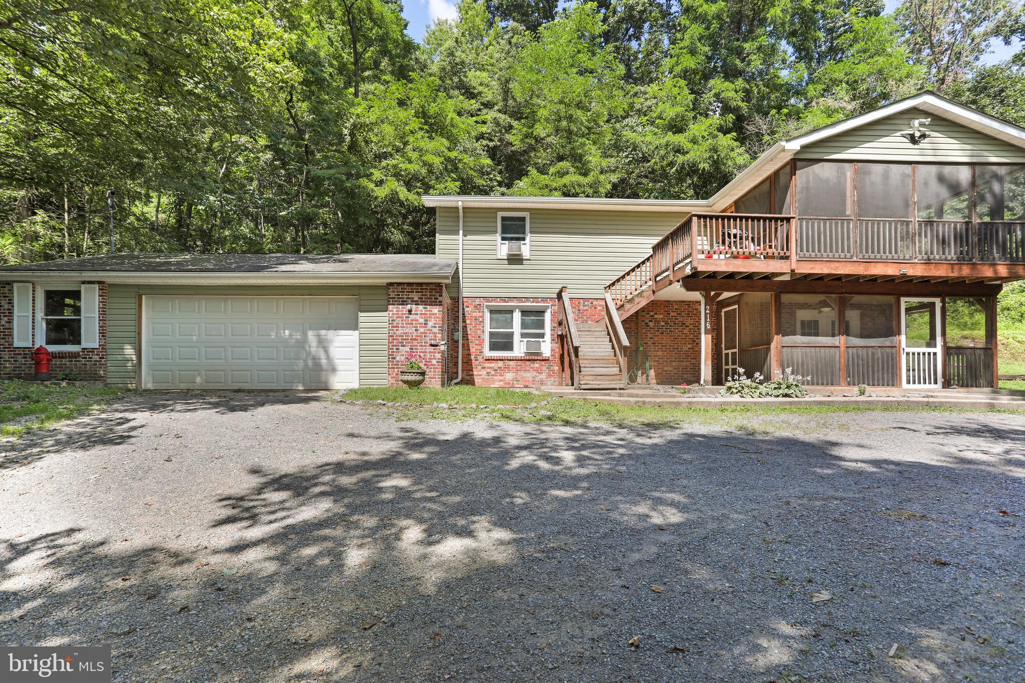 Serene living tucked on 2.61 acres this raised rancher backs to the Cacapon State Park. This charming raised rancher offers the perfect blend of privacy and convenience and less than 30 minutes from Winchester. Featuring 3 Bedrooms and 2 baths this home is designed for comfort. The open concept living area makes it easier to interact more with loved ones and fewer walls offers easier movement and makes the space feel larger.
The basement is fully finished with the main bedroom, bath, laundry and family room. The attached 2 car garage provides plenty of room for vehicles or storage. You can sip your morning coffee on one of the 2 screened porches or on the back deck while enjoying the peacefulness.
