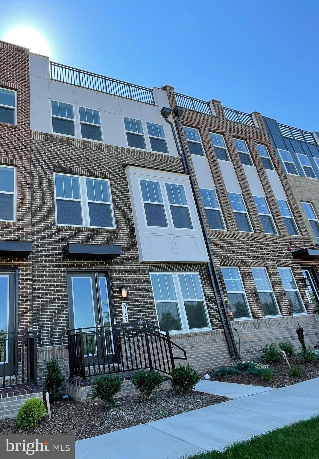 This four-story 4 bedroom 4.5 bathrooms townhome features first-floor flex space, while the second floor hosts an open kitchen and living space. On the third floor are all three bedrooms, including the luxe owner’s suite. Ideal for entertaining, a loft sprawls across the entire top floor and flows out to the terrace.
A contemporary exterior featuring concrete and brick siding with clean lines for modern appeal
Crown East is a master planned community of new luxury townhomes – steps from the rich amenities at The Retreat at Crown West and Downtown Crown’s upscale restaurants, shops, grocery store, outdoor festivals and exciting nightlife. The communities’ village green, Crown Park, offers a seasonal farmer’s market, outdoor movies and concerts al fresco. Plus, a complimentary metro shuttle runs between the community and Shady Grove Metro Station Red Line. LL prefer two year lease