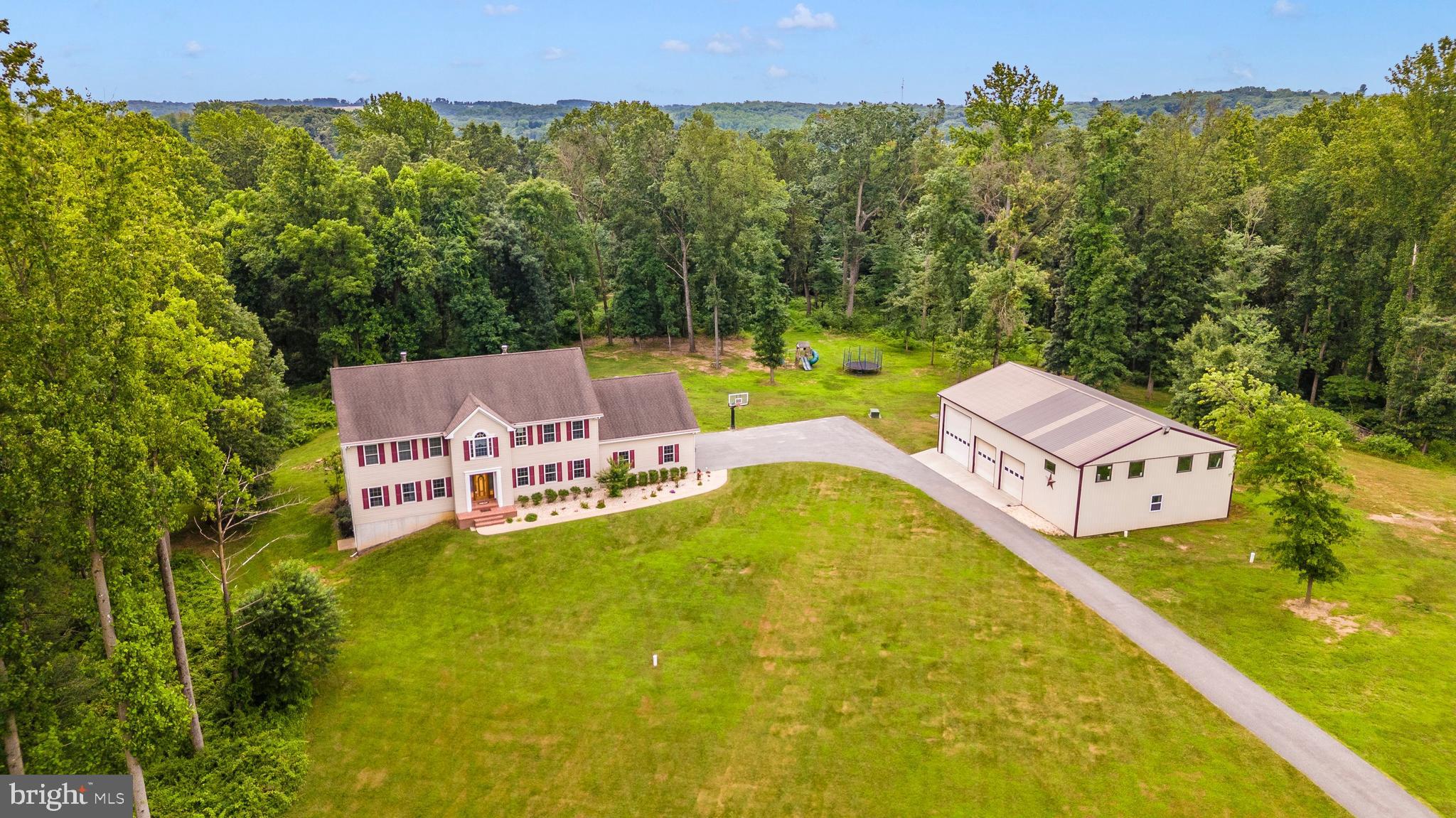 A hidden gem in Carroll County, you'll find this custom-built colonial with expansive yard and 63+ acres, which includes 50+ acres of established woodland! This one-of-a-kind home offers multiple and expansive opportunities with a separate lower level living area, 2 main level powder rooms, laundry on each floor, custom, gourmet kitchen with oversized island, ideal for entertaining. The luxury primary suite, multiple bedrooms, library, a 3 car garage, and detached 40x60 pole barn (3-bay doors with 16 ft. ceilings, separately metered and in-use water) offers endless possibilities.
The lower-level walk-out has been recently finished for 2nd living quarters, including a brand new kitchenette and full bath. There's plenty of storage and a newly added sound-proof studio. Equipped with a whole house water filtration system, constant pressure system, whole house speaker system, and security system.
Woodland backs up to a private stream with a clearing and a campsite. Miles of established trails for horseback riding, walking & recreational vehicles make access to the stream and river easy. Located on the west side of the property is the North Patapsco River. Approximately 11 acres fenced pastures with run-in sheds and watering troughs make livestock transitioning easy! Whether you're searching for privacy or wanting to set up your retreat dreams, AirBnB, or hobby farming, this property will fit multiple dreams and needs!
Extreme privacy yet still within close proximity to Westminster shopping and commuter routes MD-140, MD-97, MD-30, and I-795. Reach out to schedule your private showing of this extremely rare opportunity now!
