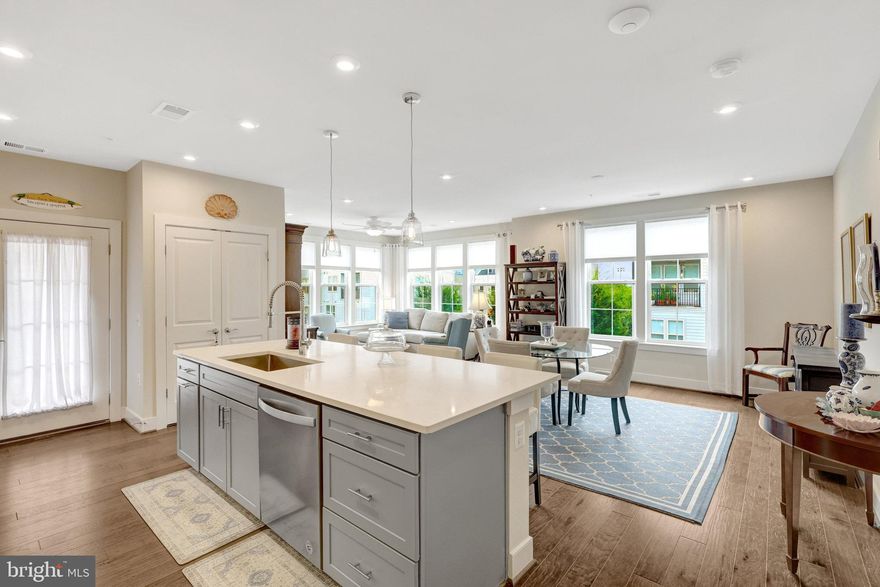 Two dedicated garage parking spaces set this home apart. Combined with a compelling new price, it’s easily one of the neighborhood’s best values.  This stunning 2 bedroom, 2 bath, corner unit condo, where windows on two sides fill the space with warm, natural light is a stunner! With 9' tall ceilings and an open floor plan, this home feels bright, spacious, and perfect for both everyday living and entertaining. The heart of the home is the gourmet kitchen, featuring a large center island w/seating for 4 & stylish pendant lighting, a 5-burner cooktop, wall oven, built-in microwave, 42"cabinets, attractive tile backsplash, thoughtful touches like built-in trash/recycling, and a spacious pantry.  Just off the kitchen, a private balcony is perfect for morning coffee or evening relaxation. The open living and dining rooms flow together seamlessly, creating a welcoming space for gatherings.  The primary suite is a true retreat, complete with an oversized walk-in closet, a double vanity, and a large frameless walk-in shower. The second bedroom is sunny and spacious with its own large closet, while a hall bath and separate laundry room add convenience.  Enjoy the safety and convenience of a secure building with an elevator. Commuting is easy with the Innovation Station metro just 1 mile away!