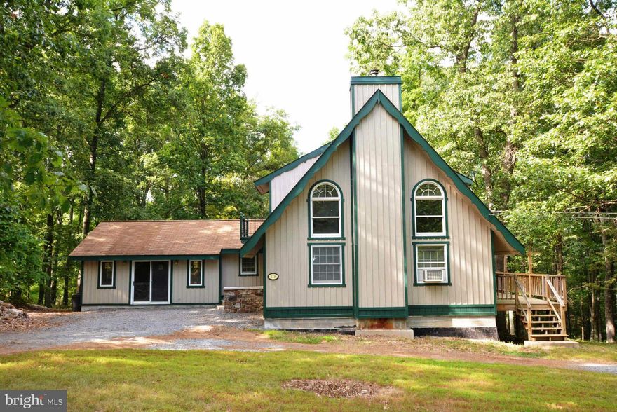 This charming chalet in the woods is situated on 4.87 acres, offers great location (approx. 20 miles) to Winchester .  Enjoy the privacy & beautiful country setting on the wrap around deck.  Home offers wood floors, large Kitchen/Dining area for family gatherings, bedroom & laundry room on main level, extra unfinished room on main level and large basement for extra storage.  Don't miss this one!!