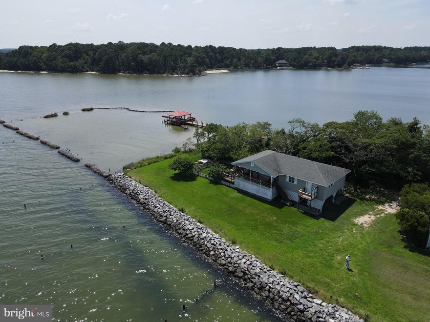 Classic coastal home with VIEWS, VIEWS, VIEWS!!  On an end-of-peninsula lot surrounded by the waters of Ingram Bay and Harvey Creek, this home enjoys sunshine and breezes galore. Multiple decks and a screened porch offer options for enjoying morning coffee, an evening sip, or just relaxing and watching the scenery.  Easy care .75AC lot  is close to the community swimming area and gazebo.  Inside, the vibe is pure early beach house. Enjoy its classic, no-worries feel or add your own updates.  Galley kitchen (with adjacent laundry area; living and dining room with water views all around; hall bath serving two bedrooms, and a primary ensuite bedroom with a separate waterfront deck complete the picture.  Underneath the house is a carport, workshop and storage area. (Note: no short term rentals are permitted).