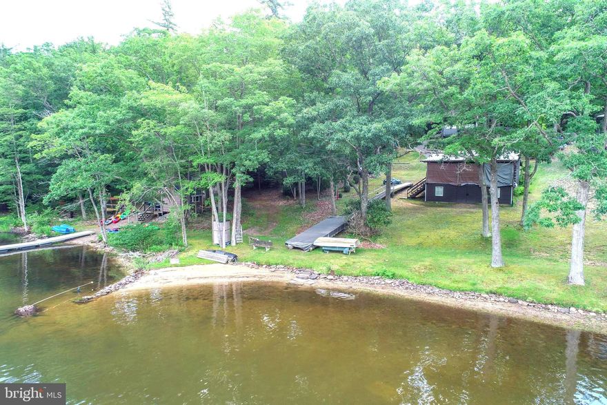 Here's your chance to own Deep Creek's oldest lakefront cabin! This original Log Cabin was built before the lake was flooded in the early 1920's! ....The Property boasts plenty of charm situated on 68 feet of the calmest Lakefront available. The property is centrally located on the lake and is just minutes from most of Garrett County's great attractions!  With a yard that connects to the water's edge and a sandy beach a unique feature for Deep Creek Lake. The property offers immediate access to all of Deep Creek State Park's amenities, that include, hiking, biking, and running trails. There's also a beach at the state park as well and plenty of room to roam. This property is located in State Park Cove. Enjoy swimming, kayaking, paddleboarding, or just sit back and enjoy the peaceful sounds of Deep Creek that surround you!  This Incredible Lakefront Property offers endless activities and opportunities!  The cabin has been a permanent residence for years and is on the public sewar. This property provides a great opportunity to expand, rebuild or just enjoy the Vintage cabin as the current owners have.