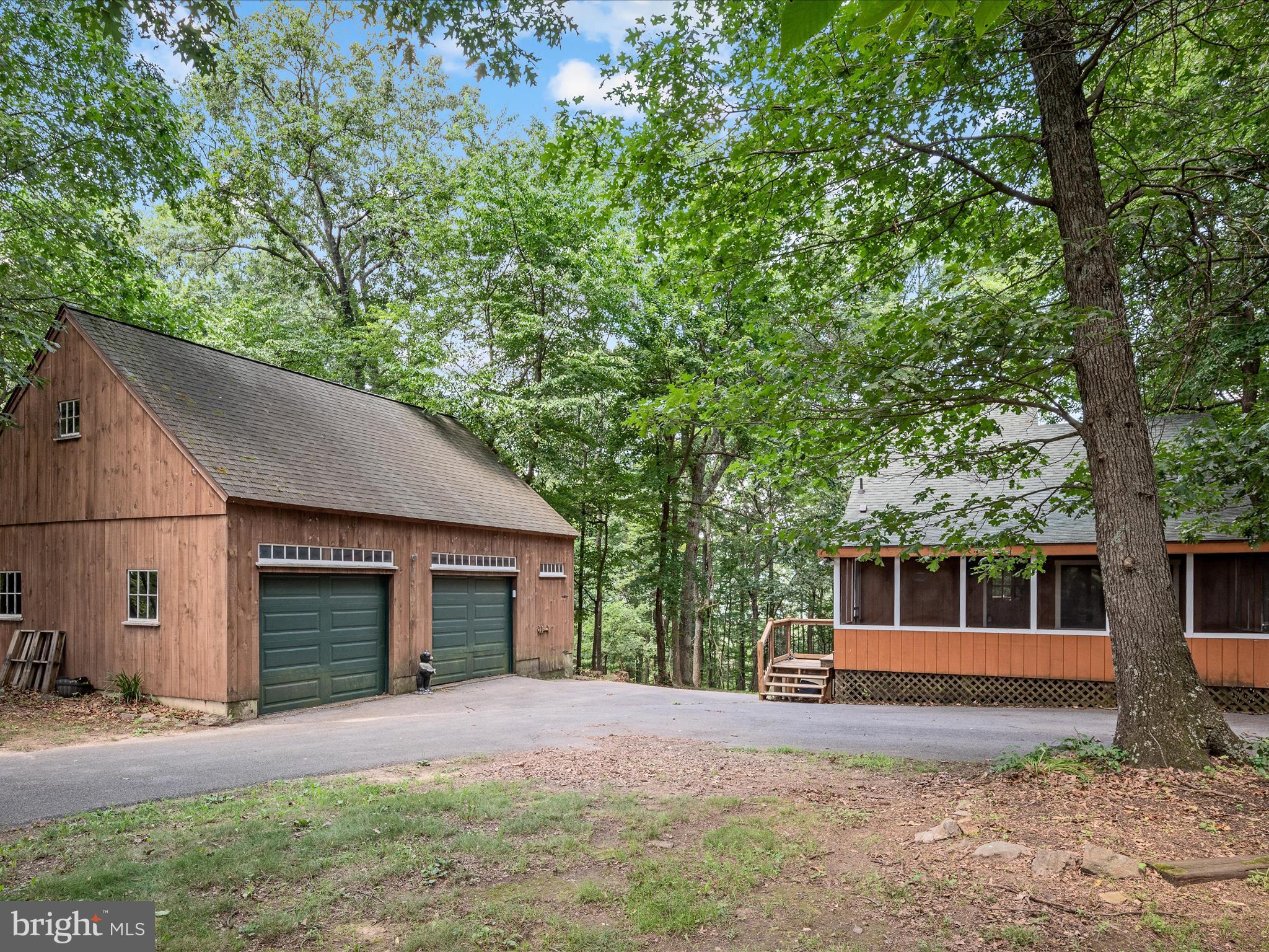 Welcome to this charming, cabin style home with an oversized garage, multiple decks, screened in porch and three season mountain views! This 2-bedroom, 1.5-bathroom home offers the perfect blend of rustic charm and modern convenience — ideal as a full-time residence, weekend getaway, or investment property. Step inside and enjoy a warm, inviting interior with an open-concept layout, wood burning, stone fireplace, main floor bedroom and plenty of natural light. Upstairs is a unique loft bedroom, complete with it's own balcony! The finished basement provides bonus living space which could be used for a den, home office, guest suite, or recreation room. Outdoors, enjoy multiple spacious decks and a screened-in porch, perfect for soaking in the views, entertaining guests, or simply relaxing with a morning coffee. The oversized garage is a car lovers dream, would make a fantastic shop or house your favorite hobby! Home sold as-is.