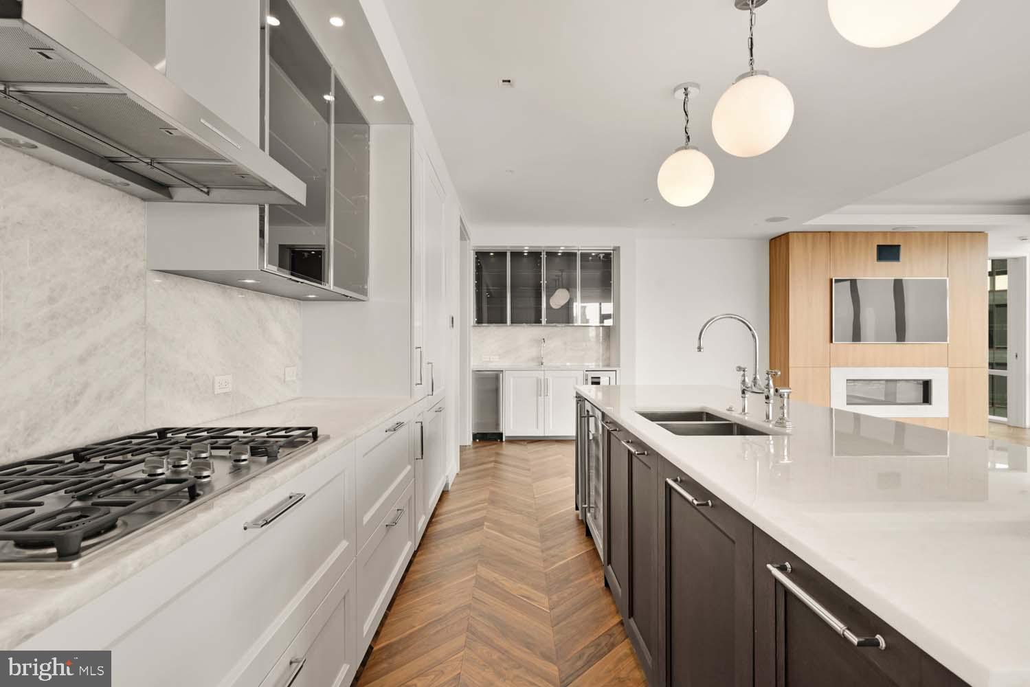 INCENTIVIZED PRICING - JUST REDUCED FROM $2,000,000!! BRAND NEW TWO BEDROOM + DEN CORNER UNIT WITH BALCONY AVAILABLE!
Welcome to the Four Seasons Private Residences in Harbor East, where luxury meets lifestyle in Baltimore’s most coveted waterfront address. This stunning two-bedroom, two-and-a-half bathroom corner unit comes with a designated den/office and was thoughtfully designed to maximize every inch, making it live far larger than its 2,416 sq ft. Step into an atmosphere of sophistication with soaring ceilings, rich walnut chevron-patterned flooring, and curated designer finishes throughout. Expansive floor-to-ceiling windows flood the home with natural light and offer breathtaking views of the Inner Harbor and iconic Domino Sugar sign from every room. The open-concept living and dining areas flow seamlessly into a gourmet kitchen outfitted with Miele appliances, sleek Eggersmann soft-close cabinetry, luxurious marble stone countertops, and a built-in Sub-Zero wine fridge. Just steps away, a wet bar equipped with an ice maker and an additional wine fridge adds convenience and elegance ideal for entertaining. The primary suite is a tranquil retreat, featuring a dressing vestibule with a massive walk-in closet and a spa-inspired, marble-clad en-suite bath. Enjoy a double vanity with designer finishes, private water closet, glass-enclosed walk-in shower with a built-in bench and niche, and a sculptural freestanding soaking tub that invites total relaxation. A dual-access balcony (accessible from both the dining area and the primary suite) offers the perfect perch to take in harbor views and fresh air. The spacious den provides flexible use as a home office, library, or media room, and every space is enhanced by motorized window shades and expansive views that change with the light.
The Four Seasons Private Residences Baltimore offers a turn-key elevated lifestyle. As a resident, you'll enjoy a private entrance where you will be met by our full service concierge and on-site building manager to assist with your every need, as well as exclusive access to the sprawling 28th-floor amenity level, where world-class services meet resort-style indulgence. Amenities include an indoor heated saltwater infinity-edge pool, a state-of-the-art fitness center, sauna, coffee station, billiard room, and numerous elegant gathering spaces. Multiple rooftop decks offer panoramic city and harbor views, complete with indoor and outdoor fireplaces, a grilling station, a dining area, and a kitchen, all ideal for entertaining. Additional perks include a fully equipped conference room and a dedicated AstroTurf dog-walking area. This residence offers the rare opportunity to live within a full-service, hotel-branded building while enjoying the privacy and sophistication of a true luxury home. All set within steps of Harbor East’s acclaimed restaurants, shopping, and the waterfront promenade. This is a MUST SEE TWO BEDROOM + DEN!! Immediate occupancy is available. Come see what all the fuss is about!