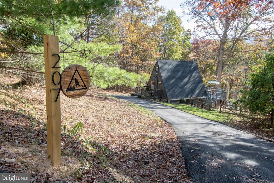 Do Not Miss the Opportunity to Own this Charming Renovated A-Frame Cabin in the Woods!
Step into this beautifully updated A-Frame cabin, nestled in a serene wooded setting. Recently renovated and in excellent condition, this home offers a cozy loft bedroom upstairs accessible via a stylish spiral staircase, plus a spacious basement bedroom with a large full bathroom. The modern, functional kitchen features stainless steel appliances, perfect for your culinary needs.
Enjoy outdoor living with a front open porch, back deck, and a patio complete with an outdoor fireplace—ideal for gatherings or quiet evenings under the stars. The under deck area, is pre-wired for a hot tub, and a large asphalt driveway accommodates 6+ cars.
This beautiful property also offers a laundry area with a front load washer and dryer for your convenience.
Additional upgrades include a new owned water softener for your convenience.
Residents of Shenandoah Farms enjoy an exclusive area accessing the Shenandoah River, making this cabin a perfect retreat for nature lovers and water enthusiasts alike. Don’t miss the chance to own this turnkey, peaceful getaway!