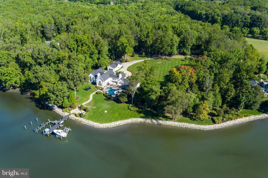 Escape to another world with this striking French modern waterfront estate. Exquisitely sited on a premium and private 4.15 acre lot with 600 feet of impressively rip-rapped water frontage, coveted waterfront pool, tennis court and picturesque views of the serene waters of Whitehall Creek. This ultra-luxe 9,000+ square-foot, 7 bedroom, 5.5 bathroom custom built home has been completely renovated. It is evident from the moment you walk in the front door that no expense was spared with this stunning home. Curated with premium quality, top of the line materials, combined with the tranquil views, exquisite design, and top-tier finishes, 1524 Cedar Lane Farm Road is truly one-of-a-kind and showcases unparalleled craftsmanship. The property both inside and out is an absolute entertainer's dream.  The lush lawn and landscaping gracefully extends to the water's edge and leads to the well-appointed multi-slip IPE pier with boat lifts, 2 jet ski lifts, upgraded power, water and great lighting including underwater LED fishing lights.  Inside, this stunning home boasts an awe-inspiring Great Room with soaring ceilings, architectural beams, and panoramic water views and features brushed Teak hardwood flooring, renovated high-end gourmet Kitchen with marble counters, 10 burner Wolf range, 5 fireplaces, Restoration Hardware lighting, renovated bathrooms throughout and much more! Fall asleep to captivating, sweeping views from the Primary's suite, enjoy watching the early morning wildlife activity on the water. Located on Whitehall Creek which flows out to Whitehall Bay and beyond to the Chesapeake Bay, you are perfectly located to take advantage of the Bay's best cruising and fishing areas. Attractive destinations such as the Annapolis Harbor, Baltimore's Inner Harbor, St. Michaels, Oxford, and Solomon's Island are only a short cruise away and just minutes from accessing Rt. 50 and 97 which provides direct access to Baltimore, BWI, Ft. Meade/NSA and Washington, DC., or head over the Bay Bridge to the Eastern Shore for a quick beach vacation.  Welcome Home!