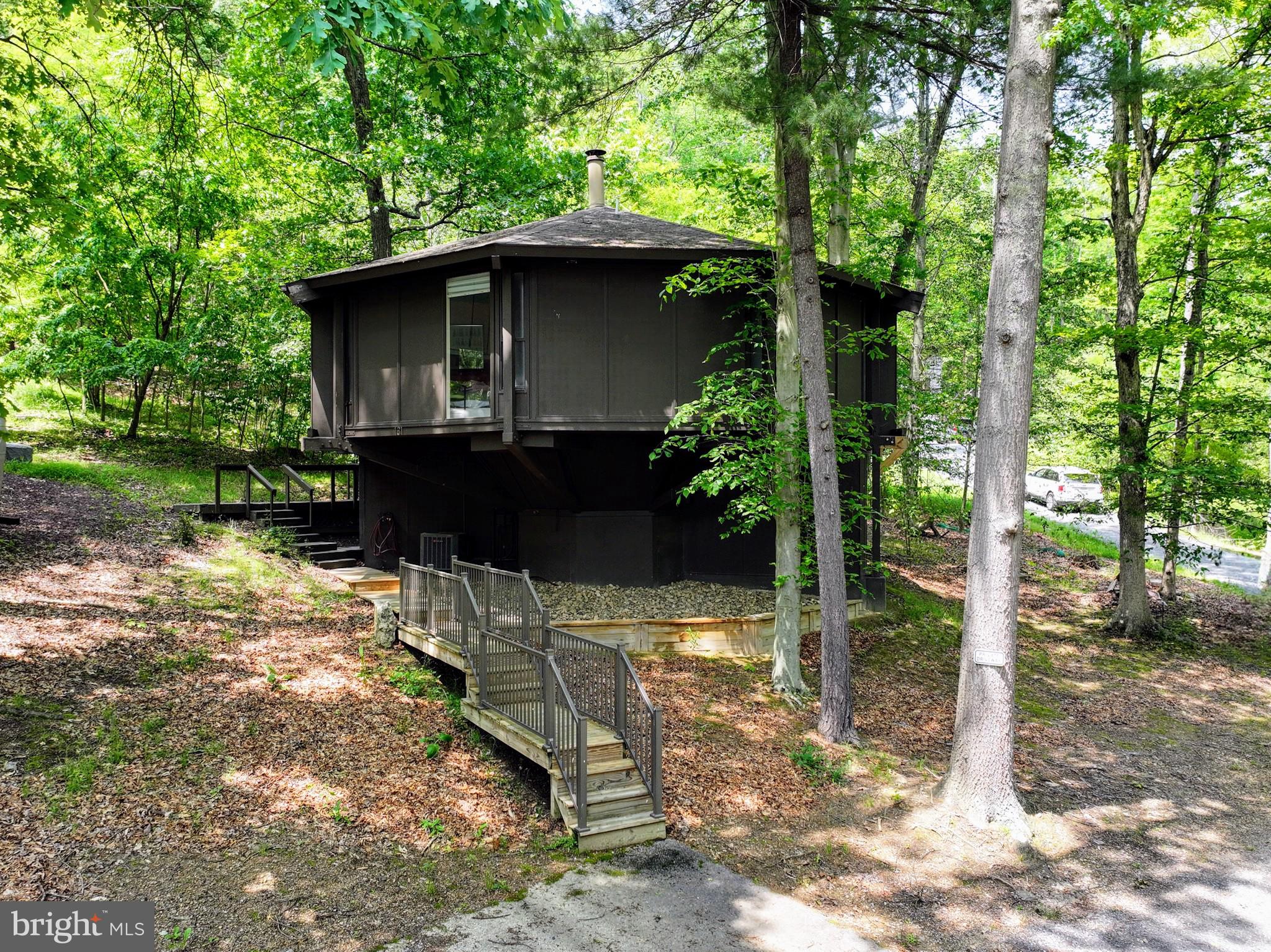 NEW PRICE!! Everyone loves these Unique Homes, this one has you feeling like you are living in a treehouse. Sits nestled across from the Award Winning Omni Golf Course and Resort. Seller bought an extra .15 lot behind for added outside space . Walk in the door to lovely Brazilian hickory hardwood floors on the upper floor. Kitchen has been updated with white cabinets, stainless appliances and butcher block counters. Cozy living room space. Two bedrooms on this level, each with its own full bath. Head down the spiral staircase into a relaxing family room/game room area with cork flooring. Lower level also hosts a third bedroom with its own bath. Heat pump forced air electric heating and central air, step down a few steps inside to the washer/dryer and utility room space. This property is turn key- walk in ready , either for your own home, rental or ARBNB. Investors come take a look. This home was remodeled in 2020. Outside has a partial wraparound deck and lower deck area, with views of the mountains and trees. Call for your tour!