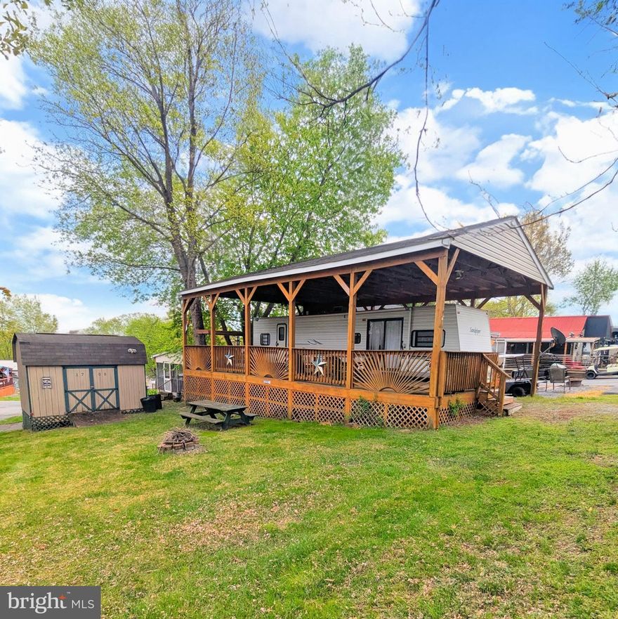 Discover this impressive corner lot that offers ample space and endless possibilities! Included with the property is a well-maintained clean travel trailer, a 2005 Sandpiper 38 BHDS, perfect for family adventures or weekend getaways. 

This camper boasts a comfortable bunkhouse located at the front, ideal for accommodating guests or providing a cozy space for kids. It features two convenient entry points, allowing for easy access from different sides. 

The property also comes with a spacious pavilion that provides shelter for the camper, ensuring you can enjoy it in various weather conditions. Attached to the pavilion is a large enclosed deck, which can serve as a fantastic outdoor entertaining space or a relaxing area to enjoy your surroundings.

Additionally, there is a large storage shed on-site, perfect for storing all your outdoor gear, tools, and equipment, keeping everything tidy and organized. This corner lot offers both convenience and the opportunity to create lasting memories in a beautiful setting. Don’t miss out on this incredible find!

Welcome to River Bend! This turn-key seasonal lot is part of a privately owned 400-acre RV camp resort offering plenty of seasonal activities for members, families, and guests. Tucked away on the Upper Potomac River in West Virginia, River Bend is one of the state’s favorite family destinations, just a short drive from the Washington, D.C., and Baltimore metro areas. Open with utilities from April 1 to November 1, lot owners enjoy year-round access to their property. Members can take in stunning views and wildlife, enjoy river access, trails, swimming pools, mini-golf, a youth center, tennis and basketball courts, laundry facilities, a convenience store, deli, and lounge. The park also features bathhouses, a boat ramp, a bar and grill, and even a church on-site. Seasonal events include 4th of July fireworks, a small carnival, bonfires, poker runs, horseshoe tournaments, a car show, Halloween trick-or-treating, and much more.