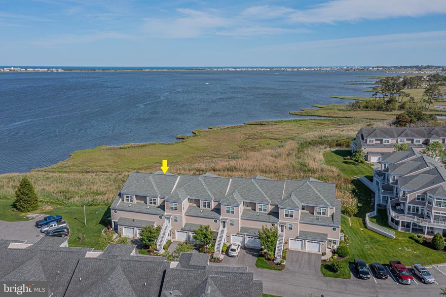 STUNNING BAYFRONT VIEWS define this exceptional 3-bedroom, 3.5-bath townhome in Bayville Shores, offering uninterrupted vistas of the Little Assawoman Bay and Fenwick Island—an ideal coastal escape. Location at the end of Ocean Vista Court within Bayville Shores is special and views are simply stunning. The first-floor primary suite is a private retreat, featuring a spa-inspired bath with walk-in shower, soaking tub, and double vanity. This level also includes a wet bar and a spacious covered patio, perfect for relaxing while taking in peaceful waterfront views. On the main living level, the open-concept great room is enhanced by a gas fireplace and expanded Florida room and opens to a bayfront deck—an ideal spot to enjoy breathtaking sunrises and panoramic water views. The well-appointed kitchen boasts high-end appliances, ample counter space, a breakfast bar, and an adjacent dining area, all seamlessly connected for easy entertaining. A conveniently located half bath completes this level. The top floor continues to impress with a guest bedroom offering a private full bath, ensuring comfort and privacy. The expansive primary suite captures sweeping bay views and features a large walk-in closet and a luxurious ensuite bath with soaking tub, walk-in shower, and dual vanities—perfect for unwinding after a day by the water. Additional highlights include a one-car garage and first-floor laundry. Bayville Shores offers resort-style amenities such as an outdoor pool, pickleball and volleyball courts, basketball courts, playground, fitness room, and a community boat ramp. Ideally located just minutes from Fenwick Island and Ocean City beaches, this bayfront townhome delivers the best of coastal living. Awesome opportunity for rental income as short term rentals are allowed in Bayville Shores