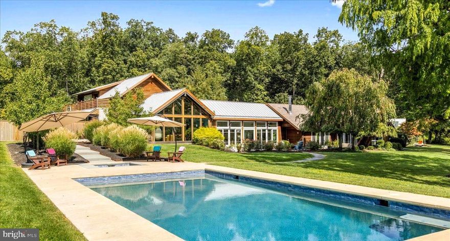 Brimming with unique personality, surrounded by complete tranquillity and exuding cool, contemporary architectural flavor, Sweetbriar Horizon presents a fashionable showcase of design, style and luxury. Nestled amidst 13+ acres of natural splendor, this modern haven is accompanied by a private pond, panoramic views, and land to expand. The striking interplay of stone, concrete, glass and natural wood creates a harmonious dialogue between built form & natural environment. The home promises a refined life marked by comfort, creativity, & functionality. Drawing on principles of mid-century modern architecture, Sweetbriar Horizon integrates the warmth of natural elements and bespoke accents, resulting in a spectacular estate that mirrors its exquisite setting. Center stage of this swanky abode is the culinary artist's dream kitchen. A series of sliding glass doors unveils a breathtaking, endless panorama of the property and allows natural light to enhance the space. The gourmet area is highlighted by a captivating Caesar stone quartzite island, augmented by a live-edge peninsula and illuminated by elegant artichoke-inspired pendant light fixtures. The room is embellished with radiant heated stone flooring, while the inclusion of top-tier appliances such as Wolf double ovens, a 72" refrigerator, dual Bosch dishwashers, and wine cooler enhance its splendor. A generous walk-in pantry provides plenty of storage, beautifully marrying aesthetics and functionality. Perfect for entertaining, grab your favorite vino, step outside, and savor alfresco dining by candlelight under the gentle warmth of the summer sun. The signature style of Sweetbriar Horizon comes alive with dramatic design accents showcasing concrete flooring, vaulted ceilings, steel headers fashioned like arrows, walls adorned w/ vertical slats, a unique wood-burning fireplace made of crushed marble and a striking custom-made tree trunk installation, all further enhancing its unique identity. All rooms are met with expansive glass windows which perfectly encapsulate picturesque scenery, promoting visual bliss from every perspective. Embracing contemporary practicality, the three bedrooms of the home are all designed with en-suite bathrooms, promising comfort and convenience. Tucked away is the principal suite- a relaxing sanctuary equipped with skylights, a private deck, a spa inspired bathroom with walk-in rainshower & soaking tub, and a two-story walk-in custom closet. At the opposite end of the house, ascend the spiral staircase to discover a secluded lounge as well as a secret doorway unveiling a bonus guest suite with a wrap-around deck.  The outdoor amenities are equally impressive. Follow the blue stone walkway to the newly installed sparkling saltwater pool which provides a panoramic view of gently undulating meadows and rustling trees. The ambiance is so tranquil, so lovely, so refined....it will leave you breathless! A small fortune was recently invested on extensive property updating and does not go unnoticed. From the western red-cedar siding, to the brand new DaVinci shake shingles and the thoughtfully curated landscape design, each detail of Sweetbriar Horizon has been methodically accounted for and executed with the utmost finesse.  A short drive will take you to the enchanting river towns of Frenchtown, New Hope,  Lambertville, & Doylestown, which offer plenty of opportunities for live entertainment, organic markets, artist exhibitions, shopping & outdoor exploration. The buzz of city life is close as NYC and Philadelphia are conveniently accessible with short proximity to major commuter routes. Every aspect of Sweetbriar Horizon has been conscientiously curated to offer a lifestyle of unparalleled perfection - a fusion of contemporary aesthetics, elemental allure, and an ambiance that encapsulates both seclusion and community. More than a residence, it is a destination: an extraordinary place to live gracefully, entertain effortlessly and escape entirely.