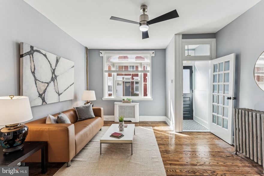 Meticulously maintained and full of character, this charming rowhome in the heart of Point Breeze is perfect for anyone ready to plant roots in a vibrant community. Bathed in southern light, the airy layout begins with a ceramic-tiled vestibule that leads to a bright living room with original hardwood floors, a ceiling fan, and window-style wall details that allow light to flow into the dining room. Beyond, a spacious kitchen offers sleek stainless appliances, abundant cabinet space, and room for an eat-in table, with direct access to the private rear patio—ideal for morning coffee, casual dinners, or summertime barbecues. Upstairs, every bedroom is equipped with a ceiling fan for comfort, including a rear bedroom with a private balcony, a well-sized middle bedroom, and a sun-filled primary suite overlooking Pierce Street. A stylish three-piece bathroom with classic subway tile and a stall shower completes the second level, while the clean, updated basement adds excellent utility. Additionally, two window unit A/Cs will be included with the home. Thoughtful updates blend modern convenience with timeless charm. Located in the very walkable and bikeable Point Breeze neighborhood, equidistant between Tasker and Snyder Avenues, this home offers excellent transit access via the BSL and various bus routes. Local restaurants like El Michtlan, Hardena, and South Philly Tap are only steps away. With sunlight, charm, and warmth in every room, this inviting home is waiting for you to embrace its next chapter. The seller is motivated --  bring an offer and make this gem yours today!