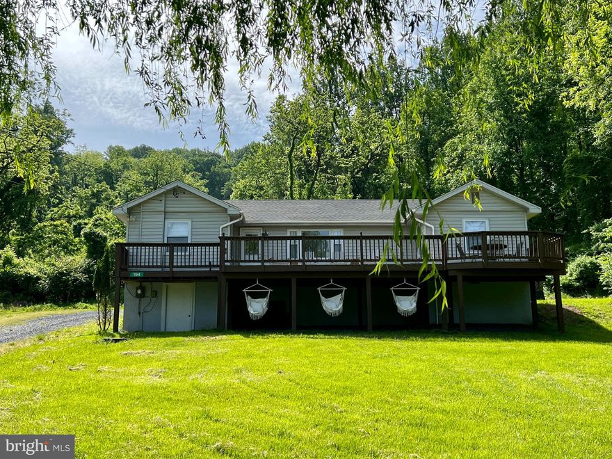 Welcome to your new turnkey rental home, private retreat, or primary home away from the hustle and bustle of Northern Virginia! (This is property is actually two lots totaling .93 acres!)  Whether entertaining in style, roasting smores around the firepit, listening to the rain on your covered back porch or just relaxing with coffee on your front deck that overlooks a tranquil spring-fed lake, there are simply no bad views from this gem!  This home has it all! The newly renovated gorgeous kitchen dazzles with marble countertops, new appliances, luxury vinyl plank floors, and updated lighting. Additionally, the primary bedroom suite features a beautifully renovated bathroom.  Boasting three comfortable bedrooms with hardwood floors throughout, this cabin is just waiting to be perfect getaway where you can warm yourself on cool evenings by the rustic wood burning stove and stone hearth centrally located in the spacious family room or enjoy some quiet time in the cozy loft accessed by the charming ladder adjacent to the dining table.  Mere minutes from the Shenandoah River, hiking trails, wineries, parks, and Upperville, this treasure is a must-see for outdoor enthusiasts. The home offers ample storage in the walkout basement and comes complete with washer and dryer as well as most of the furniture located throughout the home (please see list of non-conveyances).  Roof replaced 2021. The  Warren County Short Term  Rental Permit  conveys. 
This property contains two lots,  the current property and the land parcel that is located next to the driveway where wood shed and swing are located.   (Tax Map #15E-4-4-143, Lot 143 Shenandoah Farms, Mountain Lake, Part IV. ) The combined lot total is:   .37 acre +.56 acre  = .93 acres total.  Please call agent will all questions.