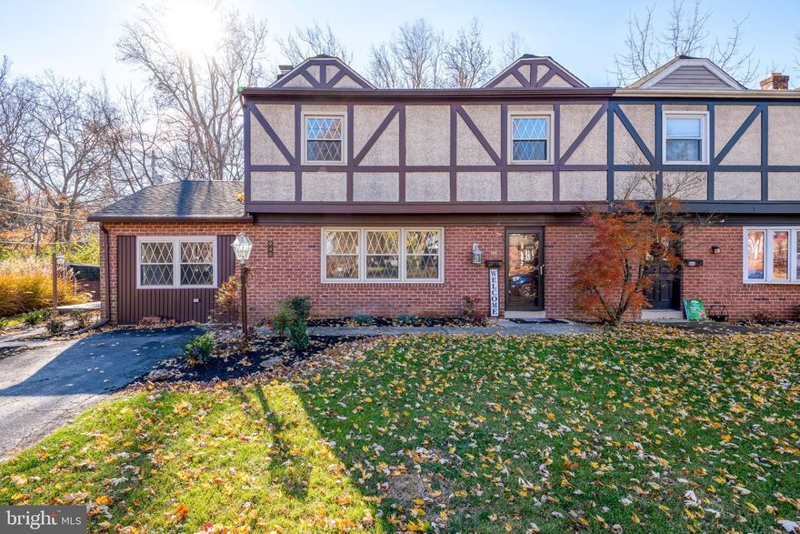 The tutor-style home, built in 1973, is nestled in the Grandview Chase area of Lancaster. As you step inside, the living room opens to your left. A brick, wood-burning fireplace will keep you cozy on a winter’s night and create the idyllic ambience for opening gifts on Christmas Eve. Lovely laminate flooring runs throughout the home, bringing warmth, beauty, and durability to the space.  From the living room, pass through into the kitchen and dining room. The large, tutor-style windows, stainless steel appliances, granite countertops, and ample cabinetry create a welcoming space for gathering. Host a Thanksgiving feast for all of your loved ones, or a quiet dinner for two.  Cooking and serving are made easy here.
A convenient laundry area is attached to the kitchen as well as a discrete half-bath that sits back a short hall. At the end of the hall is a mudroom with additional storage and access to the side porch. Also on the first floor is a bonus room that can be a family room, guest bedroom, or home office.  Upstairs are 3 airy bedrooms. The primary bedroom offers a large double-closet and light-filled windows overlooking the garden. The two additional bedrooms are warm and welcoming, with walk-in closets and lots of natural light. The full bathroom has a shower and tub and built-in linen closet. Everyone will find space, comfort, and privacy in this second-floor oasis.
A small creek runs behind the home, with a welcoming yard and side porch for you to enjoy eating al fresco on a warm spring evening. The central location of this home makes it easy to hop onto Route 30 or 222, browse the shops at Belmont, or swing through Chick-Fil-A for dinner. You have only to make this beautiful home yours.
