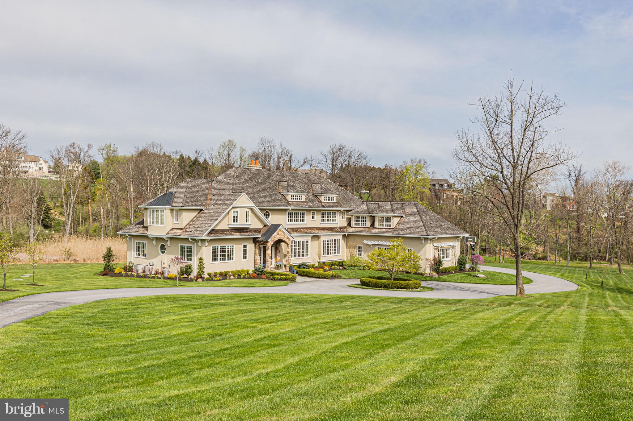 Come discover this gorgeous custom-built John Diament home on 13+ lush acres at the end of a private lane, built with the highest quality craftsmanship and materials. This home offers 5 bedrooms and 5 full baths plus 2 powder rooms across a total of 6,616 finished sq ft. With the sweeping circle drive, professional landscaping, and manicured lawn, the property abounds with charm. Featuring high-end finishes throughout its open spaces and meticulously detailed floor plan, you will find walls of brand new windows, gorgeous Brazilian cherry hardwood floors throughout, crystal chandeliers, a double hearth fireplace, vaulted and beamed ceilings, tray ceilings, a butler’s pantry with a granite wet bar, and a kitchen loaded with high-end appliances including a Sub-zero refrigerator, wine fridge, oversized honed granite island and feature marble wall above the chef’s Wolf 8 burner gas range. Directly off the kitchen is an office/ homework room with cherry wood built-in bookcases and a desk. Large-scale French doors give access to the outdoor covered terrace offering stunning views and endless entertainment options. The utility/mudroom is equipped with a dog bath and is connected to a newly built, custom dog enclosure. This estate home contains two owner’s suites (on the 1st and 2nd floors). The 1st-floor owner’s suite includes a spacious study. The stunning 2nd-floor balcony with wrought iron accents leads to four substantial bedrooms, including the luxurious and inviting upstairs owner’s suite! It has a vaulted ceiling, grand French doors to a Juliette balcony, double walk-in closets, a fantastic ensuite bath with marble flooring, a sleek clawfoot tub beneath a huge picture window, and a crystal chandelier. The second story also includes a massive playroom/game room! The oversized 3-car garage comes ready with EV charging. This is a magnificent property, with so much to offer, including low property taxes and zoning that allows for horses and a barn. Schedule an appointment today!