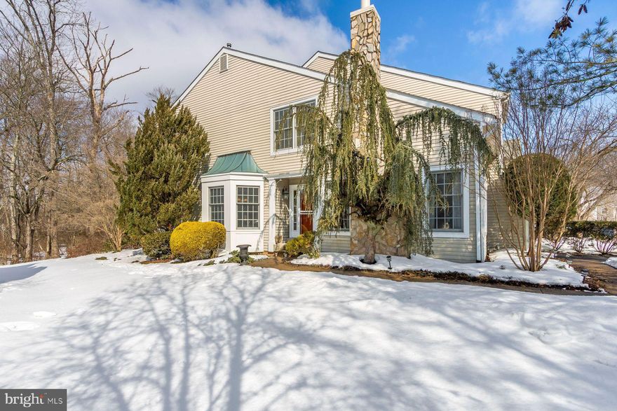 Located in the Greens of Doylestown, this lovely end unit townhouse enjoys a very special location overlooking sweeping lawn and backing to mature wooded landscape. It is the largest of homes offered in this fine community and excellent placement of windows affords a bright and cheerful setting throughout. The entry hall with hardwood floors looks on to a cozy step-down family room with mantled gas log fireplace flanked by windows, providing balance & symmetry plus an additional expansive window floods the room with light. The vaulted ceiling adds to its relaxing ambience. A pocket door to the opposite side of the entrance hall opens to the kitchen. At the end of the hallway is a half bath with attractive beaded wainscoting, marble vanity, Kohler toilet & upgraded fixtures.  A large living room with crown molding provides great wall space for art & your creative imagination! A sliding door takes you to a rear deck with pleasant surroundings. The dining room with wraparound windows is very conveniently located with direct access to the kitchen. The beautifully updated kitchen with attractive ceramic flooring, large wraparound bay window & and homey seating area offers generous cabinetry, beveled edge granite counters, and a backsplash of tumbled stone with stainless steel accents. Gas stove is offered for serious cooks! A double basin stainless sink, stainless side by side refrigerator, micro-wave, dishwasher & garbage disposal make meals effortless! The staircase with landing and clerestory space takes you to the second floor. The primary bedroom with crown molding, two walk-in closets with organizers plus full ceramic bath includes a double Corian vanity, soaking tub & separate room with ceramic shower & commode. There are two additional spacious bedrooms with large windows and double closets. A hall ceramic bath provides tub/shower & vanity sink. Speed Queen washer and dryer are conveniently located at this level. The unfinished basement provides loads of storage. Gas heat & central air complete the picture! Association takes care of common space maintenance, lawn, and snow removal & trash. There is a jogging/walking path. Make life simpler and easier! Location provides outstanding convenience for shopping!