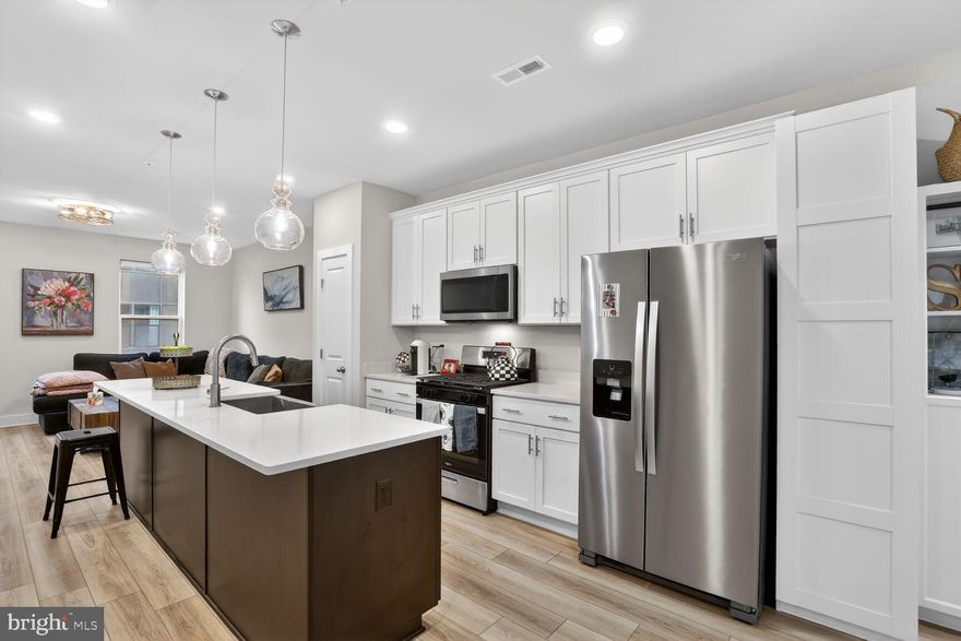 Welcome to refined waterfront community living in the sought-after community of Locke Landing, located within the vibrant Baltimore Peninsula in Baltimore. Built in 2024 and extensively upgraded, this almost-new Bridgton model by DRB Homes offers a rare opportunity to own a move-in-ready luxury townhome just moments from the water.

Imagine stepping out your front door and embracing the waterfront lifestyle—morning walks along the harbor, evenings enjoying river breezes, and the energy of one of Baltimore’s most exciting waterfront communities right outside your doorstep.

Spanning four thoughtfully designed levels, this elegant residence features 4 bedrooms and 4.5 baths, blending modern design with exceptional comfort. Over $51,000 in upgrades have already been completed, and a valuable Baltimore property tax credit transfers to the new owner for the next eight years, adding long-term value. As an added bonus, the Seller is offering a $10,000 closing credit plus a $5,000 lender credit if Buyer uses the seller’s preferred lender.

The entry level offers a versatile bedroom or private office with a full bath—perfect for guests, remote work, or multigenerational living.

The main living level opens to a light-filled open floor plan designed for both entertaining and everyday living. At the heart of the home is a stunning chef’s kitchen featuring an oversized quartz island, premium appliances, and sleek modern finishes. The dining area is enhanced with custom built-in bookshelves that convey with the home, adding warmth and character. Just beyond, a private rear deck provides the perfect setting for outdoor dining or relaxing.

On the third level, the spacious primary suite offers a peaceful retreat with generous walk-in closets and a beautifully finished spa-inspired bath featuring a double-sink vanity and frameless glass shower with dual showerheads. A secondary bedroom with its own en-suite bath and a conveniently located laundry area complete this level, providing thoughtful functionality for daily living.

The top level is a true highlight—designed for entertaining and enjoying the waterfront lifestyle. A recreation room with wet bar, an additional bedroom with en-suite bath, and a private rooftop terrace with views of the nearby Patapsco River create an exceptional indoor-outdoor living experience.

Additional upgrades include premium luxury vinyl plank flooring, elegant staircases with white risers, and a fully integrated smart home system, giving the home a polished and contemporary feel throughout.

Ideally located just minutes from the vibrant neighborhoods of Federal Hill and Locust Point, residents enjoy convenient access to waterfront parks, shopping, and dining—including everyday essentials at Harris Teeter and many of Baltimore’s most celebrated restaurants and attractions.

Sophisticated, stylish, and nearly new, this exceptional home offers the best of modern waterfront living in one of Baltimore’s most exciting new communities.