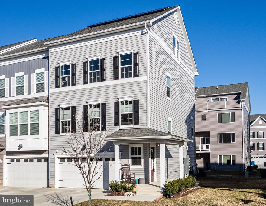 Stunning end-unit get all the upgrades included better than building new. Four-story townhouse boasting 2,855 square feet, 3 bedrooms, 3 full baths, 1 half bath, rooftop deck and a spacious 2-car garage in desirable Ellendale. A charming front porch and beautifully maintained landscaping welcome you inside the foyer. Ascend to the open-concept main level, where upgraded flooring and elegant trim enhance every detail. The living room is a showstopper with a beautifully upgraded floating fireplace set against a striking floor-to-ceiling white herringbone accent wall. The gourmet kitchen impresses with an oversized island, stainless steel appliances, a gas range, a sleek subway tile backsplash, elegant pendant lighting, and a pantry. Enjoy seamless access to the balcony from the dining area, which is conveniently accompanied by a stylish powder room. The upper level features a laundry room and two oversized bedrooms, including the luxurious primary suite with a spa-like ensuite bath and a walk-in closet. Both bathrooms on this level are upgraded with granite countertops for a refined touch. The uppermost level offers a versatile bonus space or third bedroom, complete with access to a rooftop deck. The finished basement provides additional living space with abundant natural light, a walk-out to the patio, and access to the shared open flat backyard. Additional highlights include a tankless hot water heater. The community features a clubhouse, a pool, a boat and RV storage yard, a scenic trail, kayak racks, and a fishing pier on Thompson Creek.