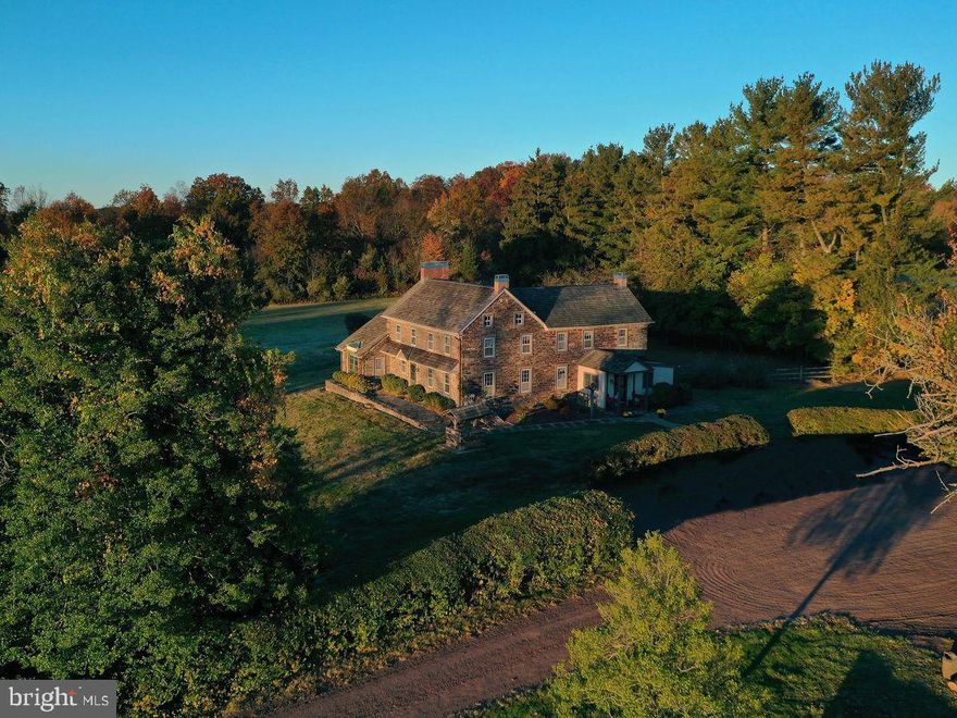 This quintessential 1830s Bucks County stone farmhouse on 8.03 acres with coveted barn, indoor RV parking, corn-crib, pond, and in-ground swimming pool boasts 4 bedrooms, 4 bathrooms, with tasteful updates throughout.  The relative openness of the first floor - an anomaly in old farmhouses – allows for the living and entertaining spaces to flow easily, while still managing to maintain the wonderful level of warmth and coziness that you would expect from a traditional stone farmhouse.  The kitchen is large and inviting with a huge stone fireplace, warm woods, and plenty of light that shines through the wall of windows in the large den, dining, and living room.  It is bookended with a spacious laundry room/mud room combination, amply sized powder room, and butler’s pantry.  There is a great and private flexible space at the bottom of the main staircase that could be used as an office, gym, or additional space for when, undoubtably, guests come to visit you.  The primary suite is an unbelievable treat in this antique home:  spacious, tons of natural light, large walk-in closet, and a spa-like bathroom with double vanity, soaking tub, and walk-in shower.  The three additional bedrooms are charming with wonderful views and share two additional hall bathrooms.  The outdoor spaces here will make your home the favorite gathering place for your friends and family - whether it be to make use of the barn that offers endless possibilities for all your hobbies, cars, trucks, four wheelers, and toys, or to enjoy barbecues on the large back patio while enjoying the 12 foot deep, salt water, gunite pool and surrounding area that offers expansive and panoramic views of the Bucks County countryside.  The home has truly remarkable utility enhancements (making it the unicorn when it comes to old farmhouses):  it has its own solar panels that generate electricity to off-set traditional electric costs (so much so, that the owners rarely have an electric bill), it was converted to public sewer in June of 2024, and is also on natural gas.  A few additional bonus features (as if there could be more!) to note:  the barn also has a large separate parking bay that will allow for your oversized RV or car collection, and the sellers believe (and have documentation) that an accessory dwelling is approved for the property.  All of this just minutes from downtown Doylestown, 25 minutes to New Hope, and easy access to 611 & 413; this property offers the perfect balance of tranquility, country living, and convenience.