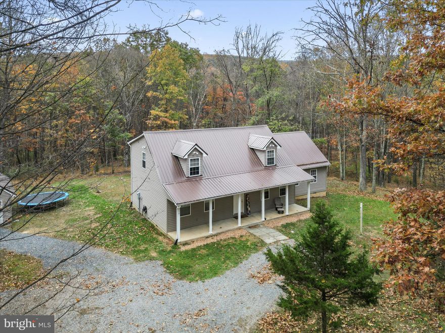 Nestled in the heart of the highly sought-after Trout Pond area, this unique mountain home offers the perfect blend of space, comfort, and convenience. With 4 bedrooms (one on the main level) and 3 full bathrooms, it was designed for both relaxation and gathering, whether you’re hosting family and friends or simply enjoying the peace and quiet of nature. Inside, you’ll find fresh paint throughout and durable LVP flooring through the bottom floor, giving the home a clean, updated feel. A large main-floor recreation and family room creates a welcoming space for fun and entertainment. Just off this area is a spacious laundry and utility room, making everyday tasks simple and efficient. From every window, you’re greeted with wooded views that create a sense of privacy and calm, no matter the season. The thoughtful layout includes a large Jack & Jill bath connecting two generously sized bedrooms, one with a charming dormer nook that’s perfect for curling up with a good book. The grand primary suite offers a sense of retreat with its own dormer sitting area, a walk-in closet, and a private ensuite bath.
One of the standout features of this home is the expansive screened-in porch with a brand-new screen, located just off the main-floor recreation room. With sliding patio doors that open wide, you can let the fresh mountain air flow in while still enjoying the comfort and convenience of the screened space—ideal for dining al fresco, morning coffee, or evening conversations. Set on 2.29 acres, this corner lot offers both wooded seclusion and easy accessibility on well-maintained gravel roads. High-speed fiber optic internet ensures you stay connected while still enjoying the peaceful setting of the mountains. The location is hard to beat: in just minutes you can be at Trout Pond Recreation Area, where a sandy beach, well-maintained hiking trails, kayaking, fishing, and camping await. For a night out or weekend exploring, you’re only 20 minutes to Wardensville, WV, with its unique dining and shopping options. In 15 minutes, you can enjoy the charming Lost River Valley’s restaurants and culture, or in 25 minutes, head to Lost River State Park for horseback riding, hiking, and swimming. This property offers the best of both worlds: modern convenience and connectivity paired with the unmatched beauty and tranquility of West Virginia’s mountains.