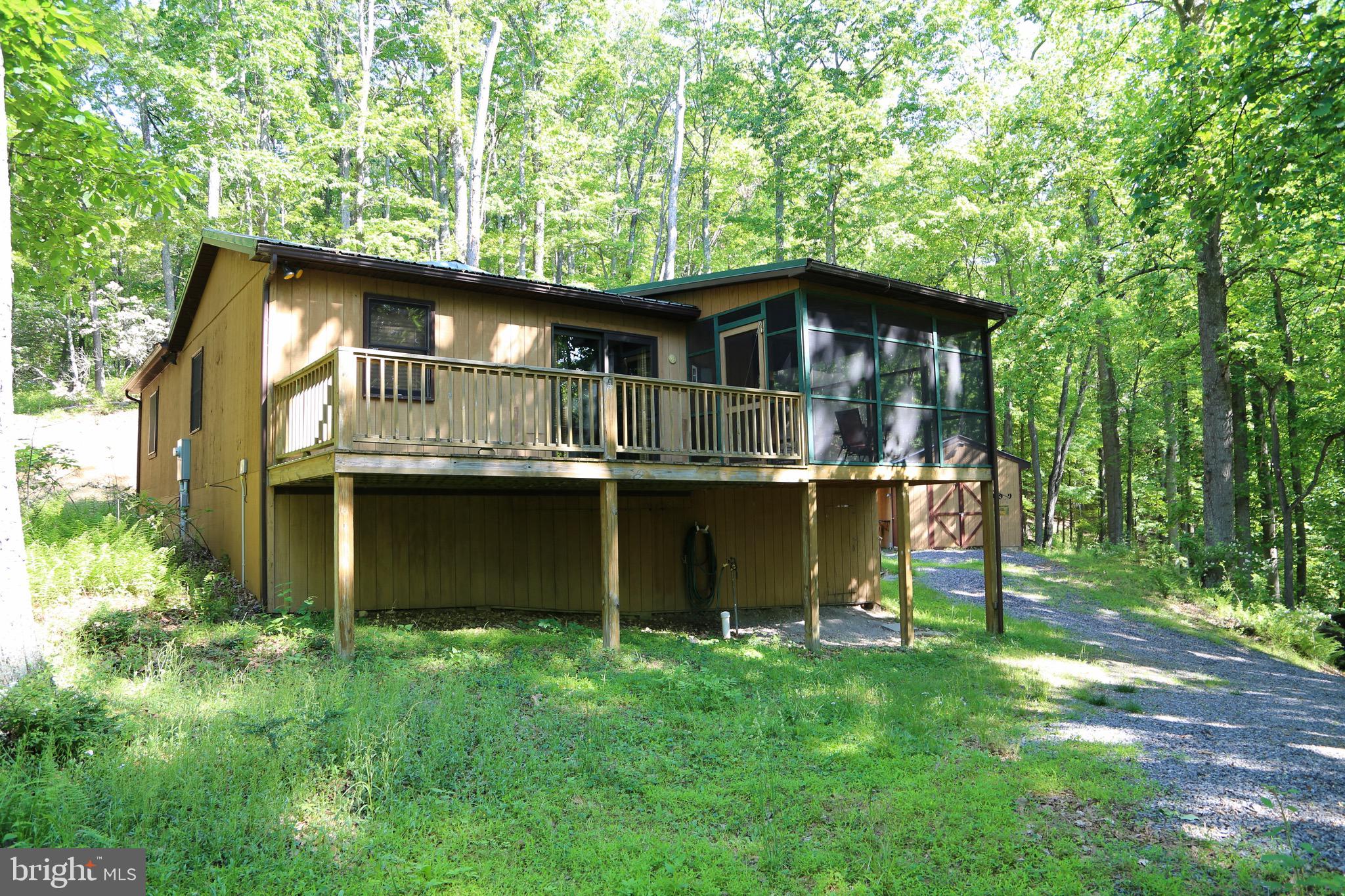 Have you always wanted to own a cabin in the woods of West Virginia? This cabin has the convenience of a wrap around deck that is partially screened in. Inside you will find 2 large bedrooms that were added on by a local licensed contractor where he matched the beautiful pinewood floors with the original part of the cabin perfectly. The kitchen still has the quaint cabin feel and is spacious and has great natural light. There is a spacious closet for storage and a washer/dryer hook-up. Pella sliding glass door takes you onto an open porch that accesses the screened-in portion as well. Outside you will find a large shed with poured concrete floor and plenty of space for storage. Photos of inside shed available upon request. Also, a lovely fire pit perfect for relaxing in the outdoors. Make an appointment today! Seller will review any offers on Friday, May 31st at 5pm.