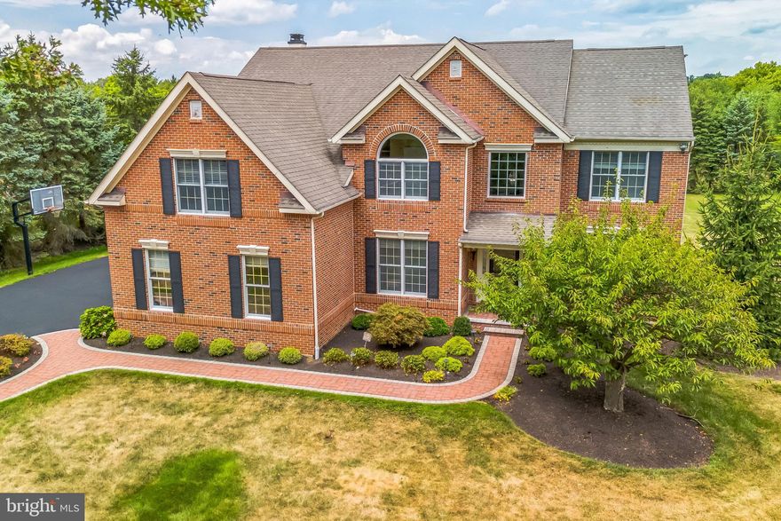Discover this spacious Lower Makefield Township home, situated on just over an acre in the Pennsbury School District. With 4,458 sq. ft. of living space, this property features a timeless brick front and a welcoming brick paver walkway. The two-story foyer, adorned with hardwood floors, leads you into the main level, where you'll find a den/study with built-in bookshelves and recessed lighting. The living room offers crown molding, chair rail, and recessed lighting, and flows into the dining room, separated by decorative columns. The dining area includes a tray ceiling and a bay window, adding a touch of character. The kitchen provides ample counter space and functionality, equipped with a gas cooktop, center island with seating, wood cabinets, and granite countertops. The adjacent sunroom offers a ceiling fan, tile floor, a pass-through to the kitchen, and access to the back patio with views of the expansive backyard. The family room, with its two-story ceiling, gas fireplace, ceiling fan, recessed lighting, and large windows, serves as a cozy gathering spot. A second staircase leads to the upper level. The first floor also includes a powder room and a laundry room. Upstairs, the primary bedroom features double doors, a coffered ceiling, ceiling fan, two walk-in closets, and a sitting room. The en-suite bathroom includes a jetted tub and double vanity. Bedrooms two and three share a Jack and Jill bathroom, while the fourth bedroom has its own bathroom. A hall bathroom provides additional convenience. The finished basement offers a full bathroom, a spacious area for entertaining, and two separate rooms that could serve as an exercise room or office. The true highlight of this property is the stunning backyard oasis. The large, level yard is perfect for outdoor activities and gatherings, while the meticulously crafted paver patio offers an elegant space for relaxing or entertaining. The patio features integrated lighting and a convenient ramp, making it accessible and enjoyable day or night. This outdoor space provides a serene retreat from the everyday hustle and bustle. While this home has solid bones and a generous layout, it offers a wonderful opportunity for customization and updates to match your personal style. New Roof was just installed in November 2024! Conveniently located near I-95 and Route 1, this property is ideal for those looking to invest in a home with potential. Don't miss the chance to make this house your own!