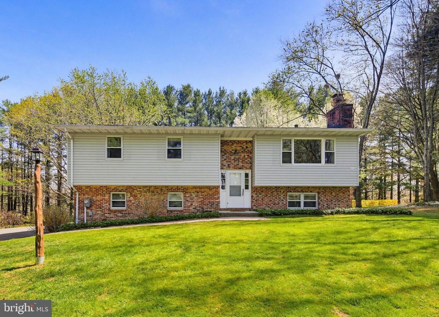 Welcome to 2701 Garrett Rd—a beautifully sited 3-bedroom, 2-bath split foyer home nestled on an expansive 2.6-acre lot, offering a rare blend of privacy, comfort, and thoughtful updates.

A multi-car driveway provides ample parking and leads to this inviting residence, where you’ll step into a welcoming foyer and head up to the sun-filled main living level. Here, hardwood floors flow throughout the spacious family room, highlighted by elegant crown molding, a cozy wood-burning fireplace, and large windows that fill the space with natural light.

The adjoining kitchen features ceramic tile flooring, a dedicated dining area, and direct access to the outdoors through a sliding glass door—perfect for everyday living and entertaining. Step outside onto the wraparound deck and enjoy peaceful views of your private acreage.

The main level is completed by three well-sized bedrooms and a full hall bath with a tub/shower combination, offering both comfort and functionality.

Downstairs, the finished lower level provides a versatile recreation space with a second wood-burning fireplace—ideal for relaxing or hosting gatherings. This level also includes a utility room with laundry and interior access to the extended one-car garage, adding convenience and additional storage.

Significant updates include a roof replacement (2021), a two-zone boiler system (2021), and a recently serviced septic system with a new baffle (2024), offering peace of mind for years to come.

Tucked away in a serene setting, 2701 Garrett Rd presents a unique opportunity to enjoy quiet living with plenty of space—both inside and out. Don't miss it!