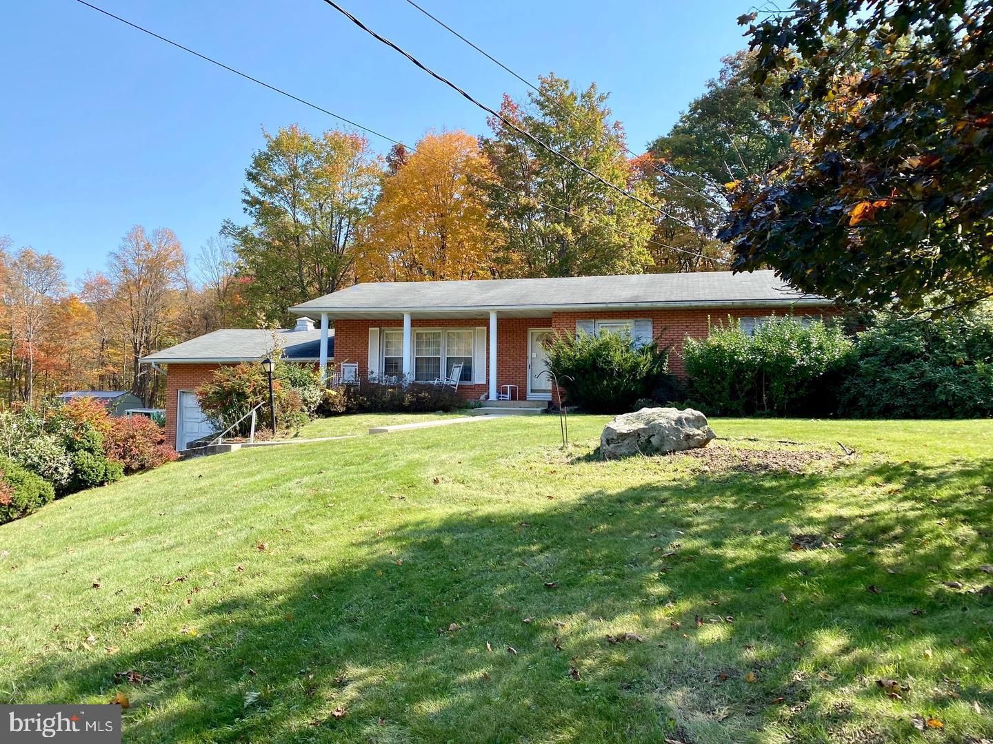 Discover comfort and space in this well-maintained 3 bedroom, 2 bath raised ranch offering over 2,000 sq ft of living space on a peaceful 0.92 acre lot. The main level features beautiful hardwood floors, a spacious living room with a cozy wood-burning fireplace, and a country-style eat-in kitchen with plenty of cabinetry and natural light. Enjoy a traditional layout with a dedicated dining area, three generously sized bedrooms, and a partially finished lower level that includes a large rec room and second full bath perfect for guests, hobbies, or a home office. Outside, mature landscaping, a private wooded backdrop, and a 2 car garage create the perfect balance of privacy and convenience all just minutes from downtown Frostburg and I-68. This home offers a peaceful setting, functional space, and timeless charm ready for its next owner.