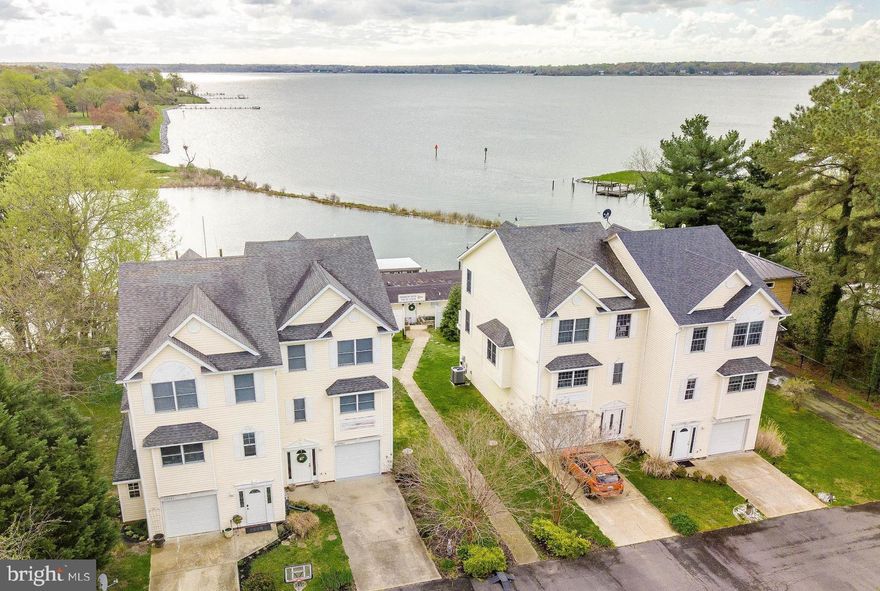 Bring your sailboat! A deeded, deep water boat slip with lift is yours with this beautiful water-oriented duplex with stunning views of Breton Bay/Combs Creek. Perfect for entertaining inside and out. Open concept main-level inc kitchen, dining, living spaces, with a beautiful water view! Lower level has custom bar and rec space with direct access to the back patio and boat slip. End-of-complex unit has nice privacy. Garage, too!