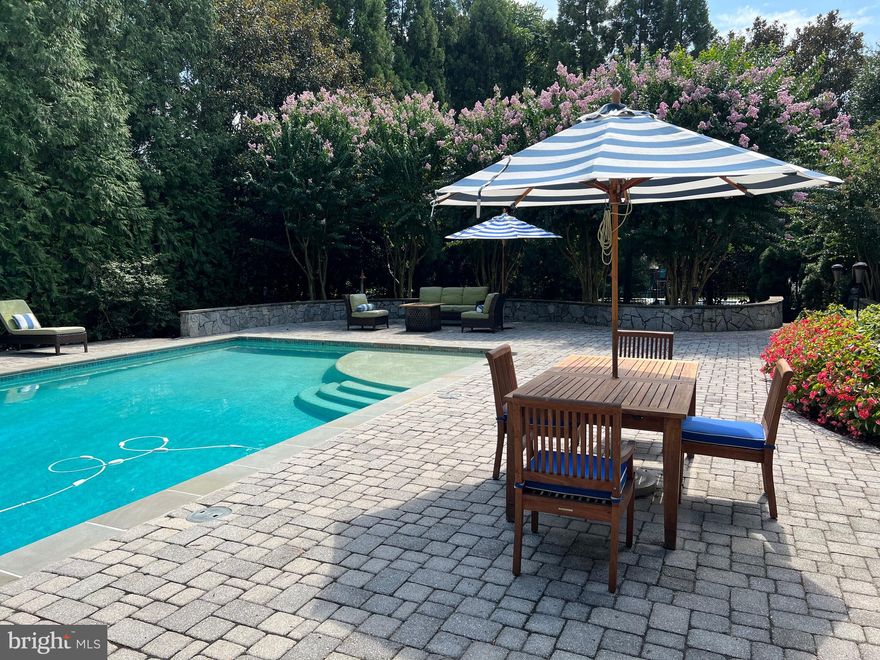 Discover luxury living in this stunning custom colonial sited on an exquisite .46 acres.  Relax in the resort style backyard featuring a large heated saltwater pool (with new coping and tile) including shallow swim platform, automatic pool cover, new deck, sunlit extensive hardscaping with plenty of room for lounge chairs, outdoor dining area, seating area, grilling space, and hammock.  Extensive landscape lighting enhances the picturesque setting, and mature landscaping provides privacy on all sides. 
As you enter through the portico of the stately all-brick residence, a dramatic foyer with soaring ceilings greets you. To the left, you’ll find the inviting formal living room with abundant light. To the right, the elegant dining room with gas fireplace. Straight ahead, the gourmet kitchen features rich cabinetry, granite counters, stainless appliances, a large pantry, and breakfast room with French doors leading to the deck and backyard. The welcoming family room includes a butler’s pantry, built-ins, and wood burning fireplace with exquisite mantle. An open sunroom with a second set of French doors leads to the outdoor spaces.  Upstairs, unwind in the spacious primary bedroom with walk-in closet, two additional closets, and two separate bathrooms. Three additional bedrooms, a Jack and Jill full bathroom and laundry room complete this level. (There are hardwood floors underneath the carpeted bedrooms.)  The spacious top floor, currently used as a home office, offers versatility and features two large storage areas with built in shelving throughout. The walkout lower level with direct access to the back yard is an entertainer's dream with tons of natural light, a fully equipped bar/kitchenette with built-in beer tap, spacious rec room, workout/multi-purpose area, wine cellar/bonus room,windowed bedroom with walk-in closet and newly renovated full bathroom - perfect for a live-in. There is an additional closet with plumbing for a stackable washer/dryer.  The location is hard to beat with shopping, dining, parks and transit within walking distance.  Commuters will enjoy the close proximity to the Pentagon, Amazon HQ2, Reagan National, and Downtown D.C.  Don't miss this rare opportunity.