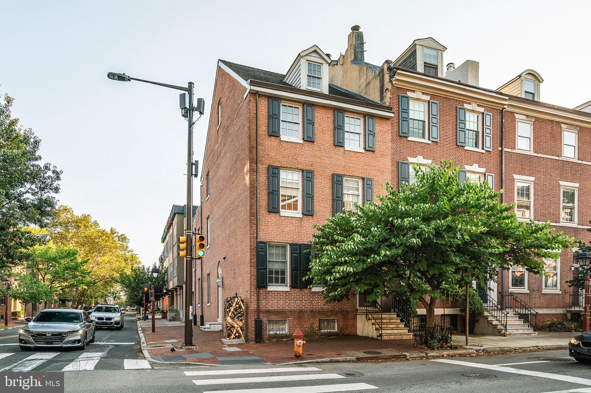 Located on a corner lot in the heart of Society Hill, find this historic home completely renovated with 4 beds, 4.5 baths, 2 CAR GARAGE PARKING and Ipe wood roof deck. Freshly painted, recessed lighting, and newly finished oak hardwood floors throughout the home. Enter through the front with original marble steps to your open concept luxury kitchen with stone countertops, island with bar seating, porcelain tiled floors, and ample cabinetry with additional shelving. A half bath with modern finishes and a coat closet flow right into your dining space with room for family gatherings and dinner parties. Living room beaming with natural light, and original charm with the marble wood burning fireplace and detailed mantle, expansive windows with wooden shutters. Access your spacious 2 car attached garage with an automatic door from this space. Travel up the open tread stairs to the first of 3 bedrooms, facing Pine St. and glowing with light. A full bath with under sink storage, fully tiled floors and bath shower combo and wall to wall closet completed this room. Down the hall is the second bedroom with a skylight, a walk-in closet with shelving, walk-through closet with desk and additional shelving that leads to the full bath with vanity storage and bath shower combo. Primary suite with tall ceilings, chandelier, walk-in closet with shelving, and renovated full bath with double vanity, tons of storage, stone countertops, and extra large completely tiled steam shower with frameless glass door. The 3rd level is a dream with a whole closet room featuring floor to ceiling cabinetry and built-in vanity, a full bath with soaking tub, double vanity with storage and tiled shower and jets. A bedroom with soaring vaulted ceiling greets you and a lofted space ideal for a home gym, studio or office awaits. A full glass nana walk lets the morning light shine in from the south and opens to your expansive Ipe roof deck. Plenty of space for a grill with a table to seat 10 and an outdoor couch or additional lounge seating. Grill out and watch fireworks on the fourth of July or have a cocktail party with friends. The opportunities are endless! Complete with a natural gas hookup for gas grill, electric, hose bib, and Ipe flooring. Any occasion is memorable in this space! The lower level expands the entire length of the home and welcomes you with a built-in bar to seat all your friends and family, sink, and cabinetry. Huge space to entertain, fit for a home theater or play room. Finish this space with a laundry room and multiple closets throughout for additional storage. Current owner added on the 2 - car garage and 2 bedroom suites, and made many other updates since purchase. This is a one of a kind property in the coveted Society Hill neighborhood and McCall Catchment. Steps from McCall School, Perth and Addison Park, Starr Garden Park, Washington Square, Penn Hospital and South Street restaurants and shops.