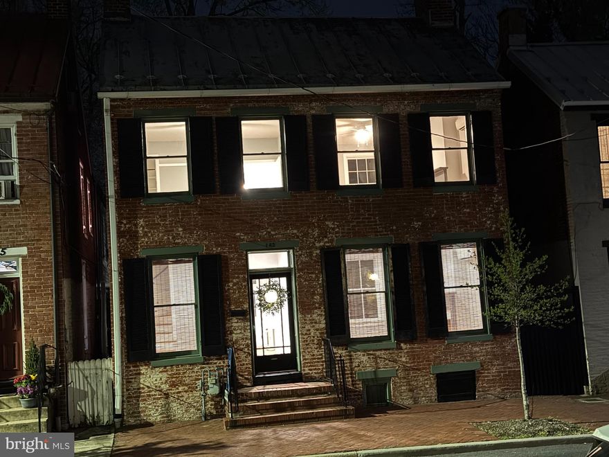 This is it!  WOW!  Beautifully restored 1850s All Brick Home with off street parking for 3 cars.  Situated on a very LARGE downtown lot,  only 1550 feet from Carroll Creek and Market St, at the heart of downtown Frederick.  As you enter the Spacious  foyer you will immediately notice 2 of the 3 fireplaces. One in the foyer and 2nd in the Formal Living Room.  As you continue through the home you will recognize the Craftmanship, attention to detail, and the original hardware. The Random Width Heart Pine Floors are Gorgeous, recently refinished.  Beyond the foyer is the Separate Dining Room and Kitchen with new Stainless Appliances. Both the Kitchen and Dining Rooms have their own access directly to the Covered Porch and Large Patio, perfect for Barbeques and Entertaining.  You will Appreciate the yard and Privacy fencing as you admire all the greenspace.  Upstairs are 3 Bedrooms, the owners Suite has the 3rd Fireplace, and access to the walkup attic.  You will Love the Marble Bathroom and convenient Laundry room with New LG Stackable Washer/Dryer.   Also, an upper Balcony for reading, rocking, and relaxing.
Updates include New HVAC Ductless Mini splits, 200 AMP Electric Service, and an abundance of recessed lighting .  Exterior features include 6 foot privacy fencing, rear gate to your own private parking, and a 22 x 14 Outbuilding. 
This home checks all the boxes.