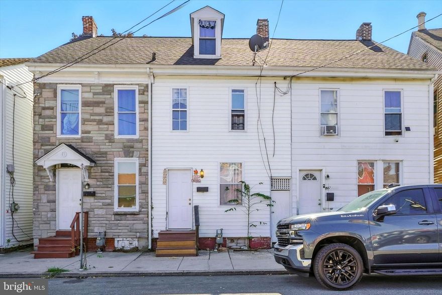 Investors dream home!  The pictures speak volumes about this home.  There are high ceilings and hardwood flooring in the living room and dining room, an updated kitchen, 1/2 bath and laundry room all on the first floor.  The 2nd floor has 3 bedrooms (1 is a walk through) and a full bath.  The 3rd floor has 2 additional bedrooms (1 is a walk through) with electric baseboard heat.  The windows have been updated and there is off street parking to the rear.