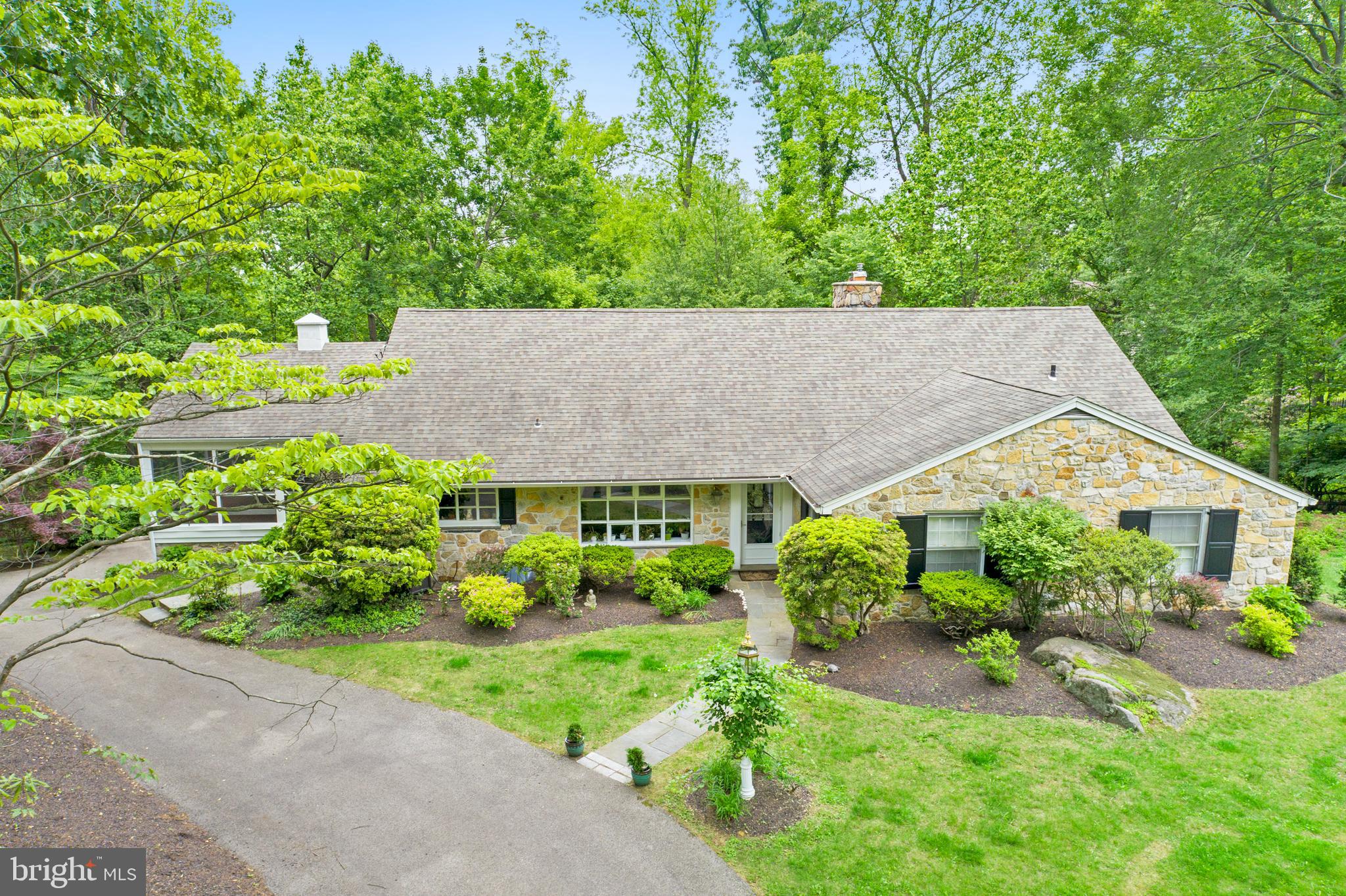 Welcome to 1626 Mount Pleasant Road - a charming 5-bedroom, 3.5-bath Stone Cape Cod nestled on a serene, tree-lined street in the heart of Villanova. Situated in a park-like setting, this beautiful home offers over 4,400 SF of living space, and is filled with natural light and surrounded by lush gardens, creating a peaceful retreat that feels worlds away—but just minutes from everything. Upon entering the home, you're greeted by the ultra spacious Living Room that stuns with a wall of windows showcasing sweeping wooded and valley views. A wood-burning fireplace and dual sitting areas make it the perfect place to unwind or gather with guests. The gourmet Kitchen is a chef’s dream with 42" cherry cabinetry, granite countertops and backsplash, top-tier stainless steel appliances, recessed lighting, and a sunny little breakfast area with glass accents. A side door offers easy access to the gardens, driveway, and covered porch. The Kitchen flows effortlessly into the formal Dining Room with crown molding, chair rail, and panoramic views—perfect for entertaining, while the cozy Family Room features a large picture window and easy access to the massive screened-in Porch ideal for dining, relaxing, or simply soaking in the scenery on a sunny day. The first-floor Primary Bedroom suite offers generous closet space and an updated en-suite bath with marble vanity and stall shower. Two additional, ample-sized Bedrooms and full hall Bath complete the main level. Upstairs, you'll find two more large Bedrooms (one currently being used as an office), tons of extra storage space, and another full Bath with limestone tile and soaking tub. The daylight walkout lower level features a mammoth-sized Rec/Great Room with second fireplace, convenient powder room, laundry/utility area, Mudroom, and access to the large, two car Garage. If you're looking for a home with ultra spacious room sizes, classic design, and a gorgeous setting, this is the home for you! A circular driveway, mature landscaping, and award-winning schools add to the appeal. Welcome home to comfort, space, and timeless elegance!