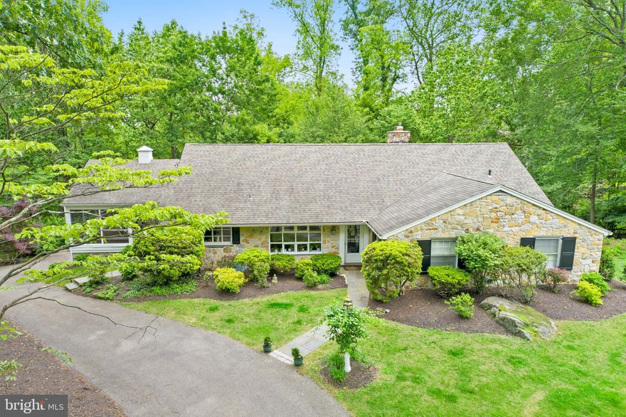 Welcome to 1626 Mount Pleasant Road - a charming 5-bedroom, 3.5-bath Stone Cape Cod nestled on a serene, tree-lined street in the heart of Villanova. Situated in a park-like setting, this beautiful home offers over 4,400 SF of living space, and is filled with natural light and surrounded by lush gardens, creating a peaceful retreat that feels worlds away—but just minutes from everything. Upon entering the home, you're greeted by the ultra spacious Living Room that stuns with a wall of windows showcasing sweeping wooded and valley views. A wood-burning fireplace and dual sitting areas make it the perfect place to unwind or gather with guests. The gourmet Kitchen is a chef’s dream with 42" cherry cabinetry, granite countertops and backsplash, top-tier stainless steel appliances, recessed lighting, and a sunny little breakfast area with glass accents. A side door offers easy access to the gardens, driveway, and covered porch. The Kitchen flows effortlessly into the formal Dining Room with crown molding, chair rail, and panoramic views—perfect for entertaining, while the cozy Family Room features a large picture window and easy access to the massive screened-in Porch ideal for dining, relaxing, or simply soaking in the scenery on a sunny day. The first-floor Primary Bedroom suite offers generous closet space and an updated en-suite bath with marble vanity and stall shower. Two additional, ample-sized Bedrooms and full hall Bath complete the main level. Upstairs, you'll find two more large Bedrooms (one currently being used as an office), tons of extra storage space, and another full Bath with limestone tile and soaking tub. The daylight walkout lower level features a mammoth-sized Rec/Great Room with second fireplace, convenient powder room, laundry/utility area, Mudroom, and access to the large, two car Garage. If you're looking for a home with ultra spacious room sizes, classic design, and a gorgeous setting, this is the home for you! A circular driveway, mature landscaping, and award-winning schools add to the appeal. Welcome home to comfort, space, and timeless elegance!