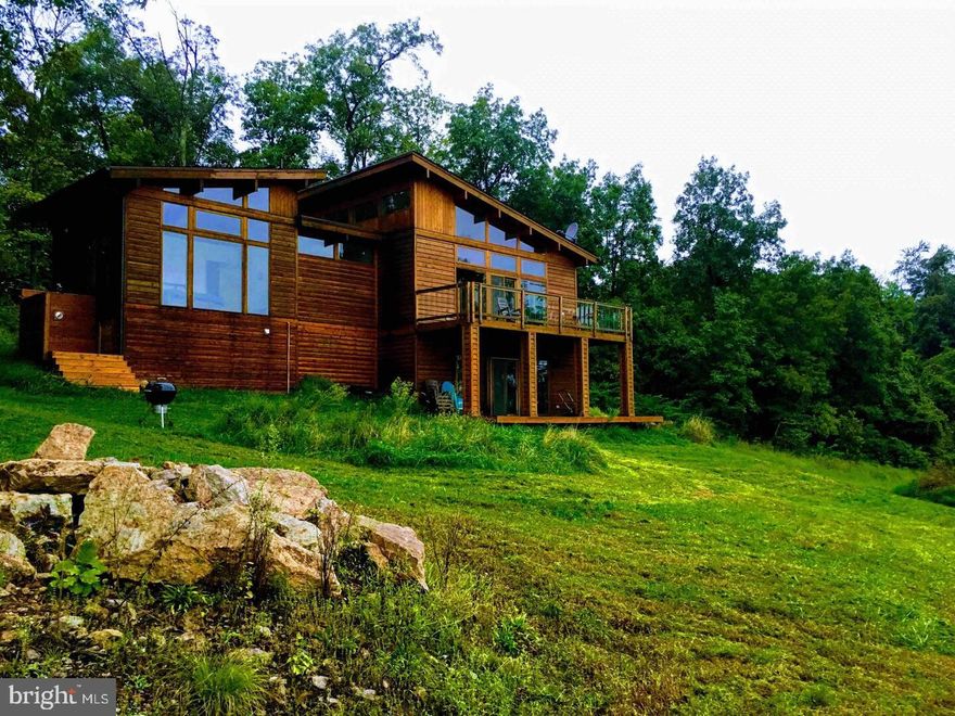 A Private Mountain Retreat with Income Potential

Escape to your own private getaway just 90 miles from Washington, DC. Perched atop a mountain at the end of a quiet 3-mile road, this spectacular property offers breathtaking, unobstructed views from nearly every room. With no restrictions, it is presently used as an Airbnb—and with all existing furniture conveying, it’s an ideal turn-key setup for continuing as a short-term rental or enjoying as your own private retreat. With $90K+ in annual revenue, buyers have the rare opportunity to step into an established, income-producing property that can help offset ownership costs from day one.

This sale includes two adjoining parcels totaling 29.84 acres, including a 15.12-acre lot with a designated perc site—perfect for ensuring total privacy or building an additional home.

The home is designed to embrace its surroundings, with walls of windows that bring the outdoors in. Enjoy a cook’s kitchen, multiple gathering spaces, and a large deck overlooking the valley below. Explore hundreds of surrounding wooded acres, or simply relax and watch the landscape change throughout the day.

Six acres of rugged meadow blend seamlessly into the remaining wooded terrain, offering a beautiful mix of open and forested land. Whether you spend your time enjoying the property yourself, sharing it with guests, or generating income, this mountain retreat offers unmatched seclusion, scenery, and opportunity.