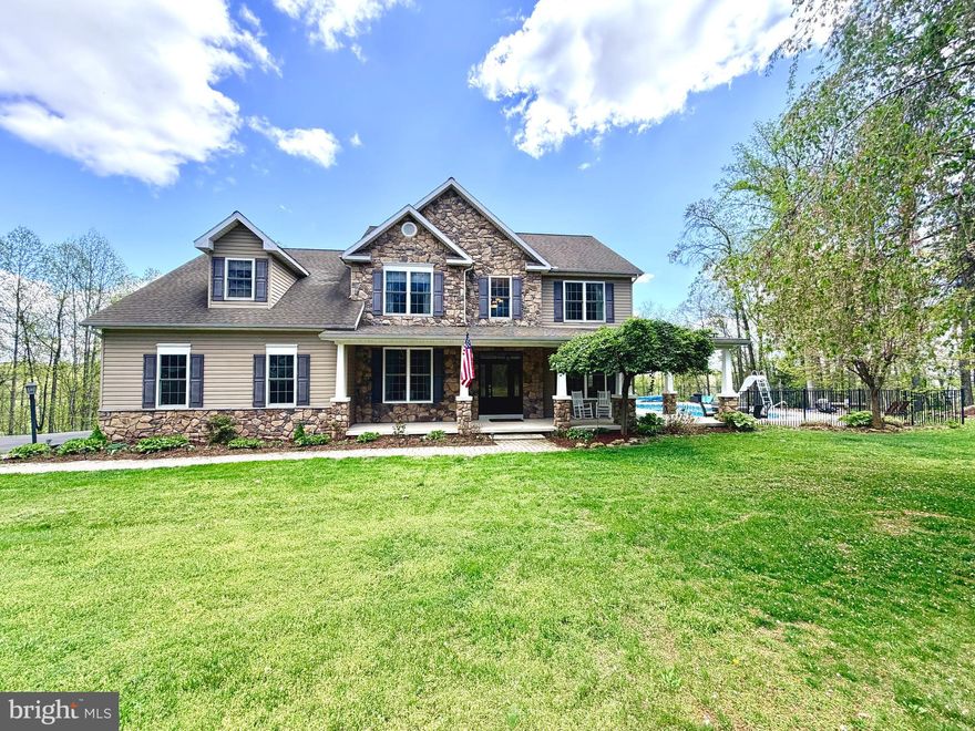 Set on over 10 private acres atop a scenic ridge, this custom-built 4-bedroom, 2.5-bath home offers more than 3,300 square feet of finished living space plus a full unfinished basement (1800+ sf) ready for expansion. Built in 2006 with thoughtful design and quality finishes throughout, the home combines comfort, functionality, and a true connection to the outdoors.

A welcoming, solid mahogany front door opens to a spacious interior featuring hardwood flooring throughout, 9-foot ceilings on the main level, and a stunning 20x24 family room with soaring cathedral ceilings. The sunroom, also with a cathedral ceiling, is filled with natural morning light, creating the perfect space to start your day. The large primary suite features its own cathedral ceiling, while three additional bedrooms—most with walk-in closets—offer flexibility for family, guests, or hobbies. A dedicated home office provides ideal work-from-home convenience, supported by high-speed fiber optic internet with 500+ Mbps download and upload capability..

The kitchen is outfitted with Silestone quartz countertops and a new range (2026), while recent upgrades including a 2024 heat pump, newer washer and dryer (2024), and a recently replaced water heater add efficiency and peace of mind. The home also features propane heat on the main level and electric heat pump on the second floor for balanced comfort.

Outdoor living is where this property truly shines. An expansive 8-foot wraparound porch on 3 sides—complete with built-in, switch-controlled outlets for seasonal lighting—overlooks beautifully landscaped grounds designed for both relaxation and recreation. The resort-style backyard includes a pool with diving board and slide, a new liner (2024), a shaded pergola draped in mature wisteria, and a separate fire pit area for gathering under the stars.

The property is equally suited for those seeking space and self-sufficiency, with three fig trees, 3 peach trees, and 2 Honeycrisp apple trees, along with a red barn ready for a chicken coop and additional outbuildings for storage or hobbies. An oversized garage with Tesla charger adds modern convenience.

Enjoy peaceful summers, vibrant fall views from your elevated setting, and even a one-of-a-kind hunting experience with a fully outfitted tree stand featuring a heater, seating, and covered porch. Many trails traverse through the property.

This is a rare opportunity to own a private retreat that seamlessly blends everyday comfort with outdoor living at its finest. Conveniently located only 0.5 miles from route 522.