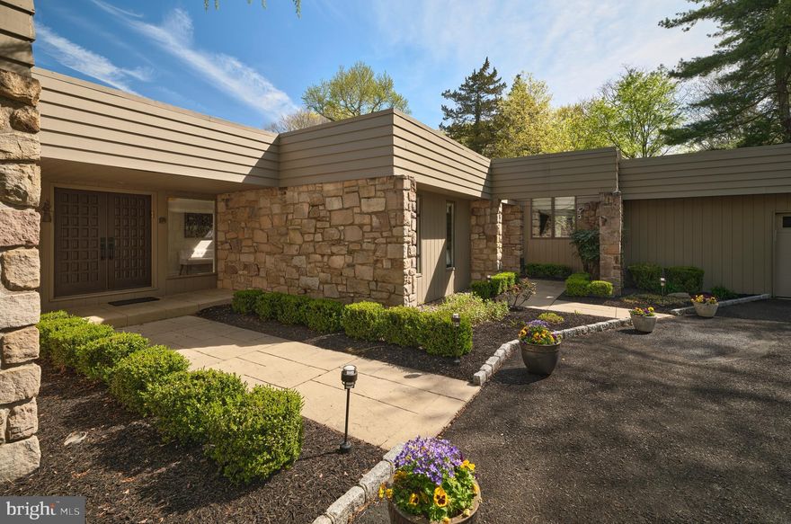 This extraordinary mid-century modern ranch home, newly reinvented, is designed for both luxury and comfort beautifully integrated into a serene, park-like setting. It's bright and airy feel, luxurious amenities, and exceptional outdoor space make it perfect for both entertaining and harmonious living. The open floor plan creates an inviting atmosphere throughout the over 5,200 square feet of living space, allowing for flexible use throughout. Wide plank hardwood floors and picture windows enhance both elegance and natural light throughout the home. Perfect for culinary enthusiasts and entertaining, the gourmet kitchen addition includes state-of-the-art appliances, custom cabinetry, center island and granite countertops. A double-sided fireplace adds warmth and ambiance to the library and living room, while a large dining room and marble bar provide ideal space for hosting - all with captivating views of the rear grounds. An expansive primary bedroom addition includes a luxurious spa bath, a cozy sitting area, and two spacious walk-in closets. There are four additional creatively designed bedrooms and bathrooms, combining style and functionality. The outdoor living space is tailored for entertainment, including a gated in-ground pool and plush lawns. Professional hardscape design and landscaping, complemented by low voltage outdoor lighting, create an enchanting environment ideal for both relaxation and gathering. Set amidst beautiful natural topography, the home offers a sense of tranquility and privacy. This home is particularly well-placed, offering close access to the canal towpath, Yardley Borough renowned pubs, and New Hope Borough - known for its charming riverside dining and theatre experiences. Located conveniently near major cities such as Philadelphia, Princeton, and NYC, making it ideal for commuters and urban lifestyles.