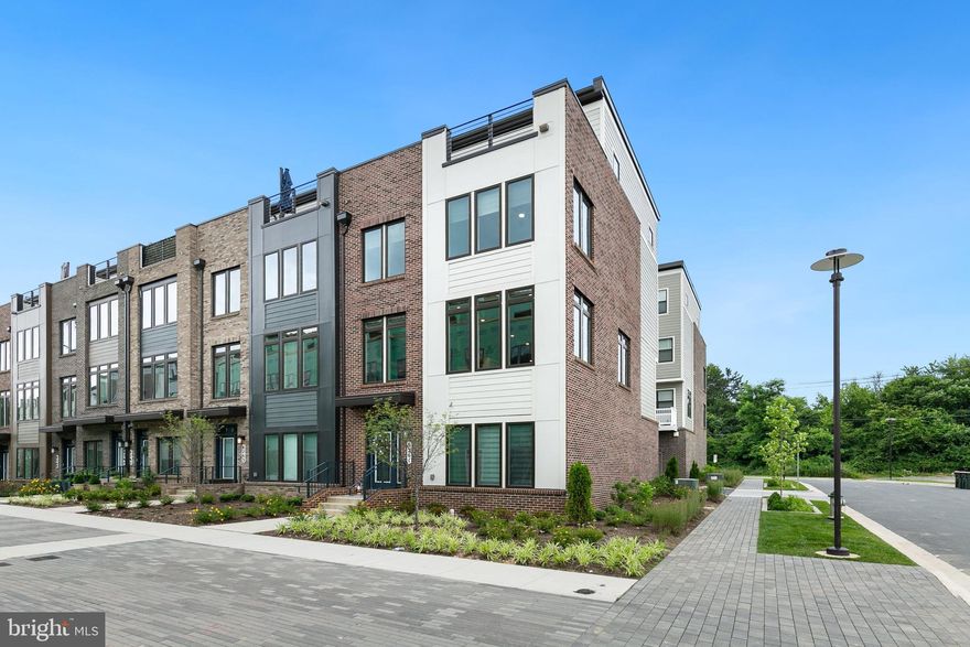 Welcome to this exquisite, like-new end-unit townhome, constructed in 2022, offering four levels of luxurious living space spanning over 2,900 square feet. This pristine home boasts 4 bedrooms, 3 full baths, and 2 half baths, all meticulously designed for contemporary living. The residence includes notable homeowner upgrades such as custom window blinds, premium ceiling fans, and a fully painted garage with durable epoxy flooring, ensuring every detail meets the highest standards of modern comfort and style. As you enter through the front door, you're greeted by a welcoming living room and a convenient half bath. Alternatively, access the home through the rear two-car garage, ensuring ease and functionality. As you enter the second level, you'll be captivated by the gourmet kitchen, a chef's dream come true. This state-of-the-art kitchen is equipped with a massive center island that provides ample space for meal preparation and casual dining. The kitchen boasts top-of-the-line stainless steel appliances, including a double oven and a gas range, ensuring you have everything you need to create culinary masterpieces. A large pantry offers abundant storage, while custom cabinetry and a designer backsplash add a touch of elegance. The kitchen seamlessly flows into the adjacent dining area, creating an ideal space for entertaining.  Enjoy morning coffee or evening meals on the back deck. The spacious living area, also on the second level, features a cozy fireplace, perfect for unwinding on chilly evenings. The third level is dedicated to private quarters, with the primary suite serving as a luxurious retreat. This expansive suite includes a walk-in closet and a lavish en-suite bathroom featuring double vanities and a glass-enclosed shower. Two additional bedrooms on this level share a well-appointed hall bath, providing comfort and privacy for family members or guests. The fourth level offers a versatile living room with French doors leading to a stunning rooftop deck, perfect for outdoor entertaining. This uppermost level also boasts the fourth bedroom and a full bathroom, offering privacy and comfort for guests. This exceptional townhome combines modern design, premium finishes, and ample living space, making it the perfect place to call home. Walking distance to Shady Grove Metro (Red Line), Starbucks, CVS and Giant. Easily access ICC, I-270 and I-370.  Only minutes to King Farm, Downtown Crown and Rio Lakefront for endless dining, shopping and entertainment. Community amenities include a resort style pool and clubhouse, fitness center, fire pits and patio, dog park and a future community garden.