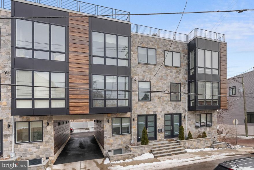 A stunning showcase of architectural details and craftsmanship rarely found in modern homes! 
Built in 2022, 311 Delmar St is bright, airy, and anything but cookie-cutter, offering 4 bedrooms, 
4.5 bathrooms, an oversized garage + driveway parking, an expansive roof deck, and a prime 
Manayunk location. First impressions are impressive thanks to the towering stone facade. 
Inside, you’re welcomed by a soaring 2-story foyer with hardwood floors and board-and-batten 
tracing the walls. A convenient powder room, a coat closet, and direct garage access make 
this space ideal for a mudroom, office, or organized drop zone. The heart of the home unfolds 
on the open, sun-soaked main level, thoughtfully designed to take full advantage of the extra
wide lot. Here, wrought-iron railings frame the staircases and act as architectural anchors, 
subtly defining each space while preserving the airy feel and seamless flow. At the front, the 
living room is filled with natural light from floor-to-ceiling windows while a fireplace centers the 
space for cozy nights in. On the opposite wing, the all-white chef’s kitchen is beautifully 
appointed with 42” shaker cabinetry, quartz counters, stainless steel appliances, a pot filler 
over the range, a tile backsplash, and an island with seating and pendant lighting overhead. 
Additional built-in cabinetry sits by the dining area. Completing the level are a pair of sliding 
doors that lead to a covered terrace where you can relax with a morning cup of coffee. The 
home’s fourth floor continues the thoughtful design with a highly functional layout. You’ll wake 
up to serene treetop views in the spacious primary suite, which boasts a Juliet balcony, 
hardwood floors, a board-and-batten feature wall, a walk-in closet, and a spa-like bathroom 
adorned with heated floors, a floating double vanity, a soaking tub, and a glass-enclosed 
rainfall shower. Off the hall is another, bright bedroom suite, a third bedroom and bathroom, 
and the laundry closet. The fourth bedroom suite, found in the basement, can be used for 
guests or as a gym. Topping off the home is a huge roof deck, perfect for hosting spring-time 
parties with friends and family. Utilities include multi-zone HVAC, gas heat, and a gas tankless 
water heater. In addition to everything inside 311 Delmar St, it's only a block from the shops 
and markets on Ridge Ave and 5 minutes from the popular restaurants, lively entertainment, 
and community events on Main St. Sprawling parks and extensive trails are close, plus there's 
easy access to I-76, Henry Ave, and Montgomery County. Schedule your showing today!