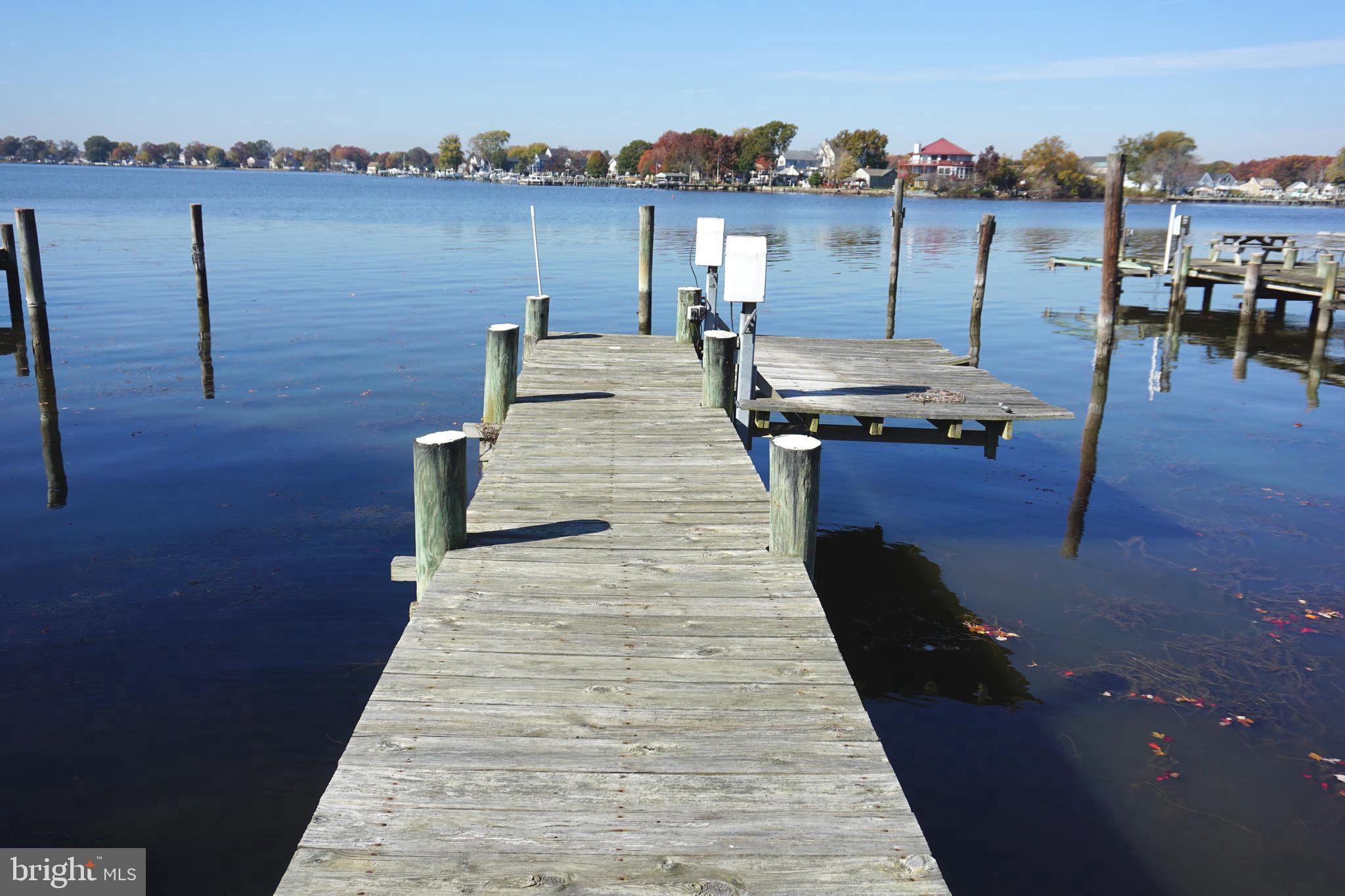 "Spectacular Waterfront Living" Large Rancher (Lexington Model) w/ 9ft. ceilings. Ground level living at its finest, 3- full bedrooms 2- full baths 2- car oversized attached garage 30X20 w/ floored attic for storage. Street entrance has covered lighted walkway w/ pond, landscaping and a covered 11X13 deck at the rear (street) door. Enter into the 13X33 living rm/dinning rm combo area with all (Pella) upgraded windows for plenty of natural lighting. All three bedrooms are generous in size the Primary bedroom is 12X20 including ensuite bath, w/French doors that lead to the huge waterfront 20 X 12 family room addition that has cathedral ceilings & lg. bay window for scenic views. Off the dinning room area the front door leads to the waterfront entrance via maintenance free decking & stairs, w/vinyl banisters. Kitchen has beautiful Granite counter tops, Stainless sink, Hickory cabinets, New Frig, ceramic flooring, a wood stove & recessed lighting. Off garage entrance there is laundry rm & pull down stairs to floored lighted attic. **High lights are 3/4" hardwood flooring, lighted ceiling fans, & recessed lighting throughout. *Updates: New Carrier Heating/AC 2014, New water heater2022, New Roof 2020, New frig 2024, Newer wash/dryer, Newer wood stove, New grinder pump 2022. *For boating a 33 ft private pier w/ electric lift & plentiful wildlife, and scenic views. -Major commuter routes include I-695, I-95, Rte. 43, Rte. 40 and MD-702. **House has never flooded! *Property is ZONE X (500 YEAR ) flood = not in flood zone **panel #2400100445G (out of SFHA) WITHIN 250 ft of multiple food zones.