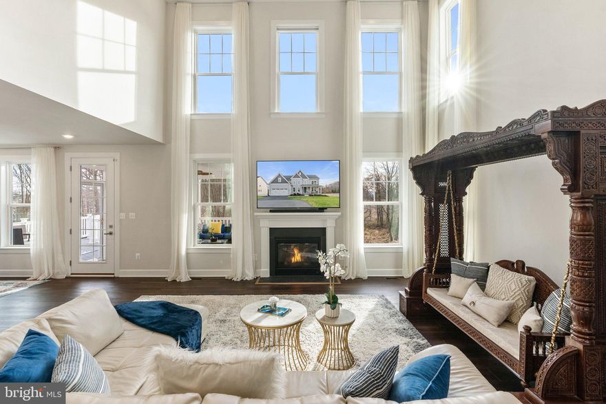 Located in the highly esteemed The Grant at Willowsford, this Northeast facing stunning home boasts a premium lot, with a rare flat backyard leading to an open conservatory area, and allows for optimal natural light throughout the day. The upgrades in this home are worth over $300k, including uplighting on the house and walkway, backyard lighting, an irrigation system and professionally maintained landscape. The massive backyard patio with seating wall and a screen porch are perfect for hosting guests. The deck with a staircase to the patio and 220 electrical work allows for a swim spa or backyard kitchen to be installed. Custom paint on all floors adds a personal touch to this already stunning home.
The main floor features a seating room with an accent wall and woodwork, a 2-story family room with a coffered ceiling, upgraded chandeliers and over-sized kitchen island with quartz countertop. The upgraded appliances and redesigned pantry with butcher board countertops are a chef's dream. A main floor bedroom with a customized full bath featuring a standing rain shower adds a touch of luxury. 
The walk-out basement is an entertainment oasis, featuring a wet bar with a quartz countertop and mini-fridge, hardwood flooring, and an additional flex room. The movie theater and additional bar seating with quartz countertop provides the perfect space for movie nights and entertaining guests. An additional GE fridge with water line and ice maker is the cherry on top.
This home also features a fully redesigned laundry room located on the second floor, providing ease and convenience. The primary suite is a true oasis with a custom accent wall adorned with new luxurious paint and breathtaking views. The primary bathroom is equally impressive with ample space, separate sinks, a beautiful bathtub, a spacious shower, and a majestic his and her fully done up walk-in closets. This home truly has it all - luxury, comfort, and convenience - and is the perfect place to call home.
The neighborhood is renowned for its unparalleled combination of luxury, privacy, and natural beauty, with easy access to the finest amenities and conveniences of modern life. This stunning residence is the epitome of opulence and refinement, promising the most discerning buyer the ultimate in luxury living in an unbeatable location, Willowsford.