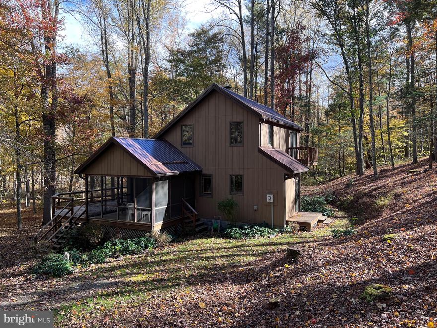 This property has 205' of frontage along the Cacapon River!   Imagine the season's from your home in WV.   Have lots of fun enjoying your very own private frontage along the river and enjoy all the colorful leaves in the fall!  This charming home features: Great Room with high wood ceilings, wood burning fireplace and balcony overlooking the Great Room. Fully equipped Kitchen with Closet & stack washer & dryer, main level Bedroom and dual entry Bath. Upper level features 2 additional Bedrooms (1 BR is open) with a Jack and Jill Bath. Enjoy the screened in porch, and the path to the river front access. Situated on 3 acres in Morgan Wood Subdivision.  Across the river is a 51 acre Wildlife Sanctuary. There is also a common area along the river just as you turn into Morgan Woods. Pack your bags and come relax most furnishings convey!  Frontier Internet and Air B&B's are permitted.