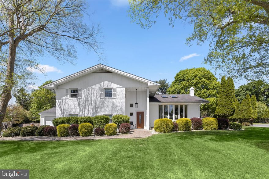 Presenting this exceptional one-of-a-kind home in the sought-after Long Meadow Estates in Pikesville, offering five bedrooms and three full bathrooms, spread across four levels. Multiple thoughtful additions over the years have expanded this sprawling residence, creating a home that truly feels custom built. Set on a level half-acre corner lot, this home has generous space for everyone both inside and out. Step inside to discover an abundance of natural light, beginning in the inviting front living room with a sun-filled bay window and a vaulted ceiling with skylights. Rich hardwood floors, crown molding, and recessed lighting continue into the dining room, providing a comfortable setting for gatherings of any size. Prepare your favorite meals in the eat-in kitchen, complete with a center island with seating, ample cabinets for storage, and appliances including a Bosch dishwasher and refrigerator/freezer, a JennAir gas cooktop, and double wall ovens. Just beyond, the sunroom addition boasts a soaring cathedral ceiling with skylights, oversized windows, and a wood-burning fireplace. Designed for year-round enjoyment, it offers a relaxing space with direct access to the patio and backyard. The upper level hosts the primary suite, complete with a separate sitting room with three closets, a spacious bedroom with a walk-in closet, and a well-appointed ensuite bathroom featuring a walk-in shower, jetted tub, and dual-sink vanity.  Completing the upper level are the second and third bedrooms, along with a hall bathroom. The finished lower level has two additional bedrooms and a third full bathroom with a walk-in shower. A comfortable family room with a cozy wood-burning fireplace and sliding glass doors outside provides additional living space, while a versatile den with a wet bar and garage access is ideal for an office or potential bedroom. The basement level offers laundry, extensive storage including two walk-in closets, and flexible space for a gym or hobbies. Outside, the backyard is designed for both relaxation and entertaining, featuring a paver stone patio with a convenient gas line hookup for a grill. Recent updates within the last few years include a new gas furnace (2025), gas water heater (2021), most of the kitchen appliances, sunroom skylights and windows, driveway resurfacing and more. Additional highlights include a generator, electric vehicle charger, zoned heating and cooling systems.